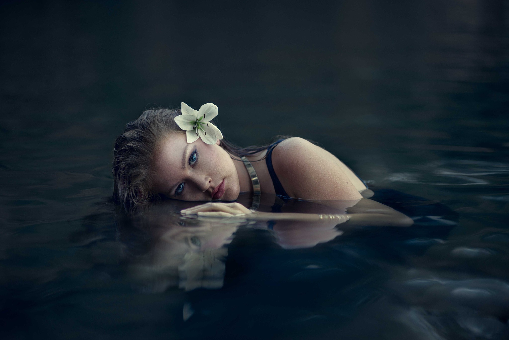 Woman with flower in wet hair in dark water HD Wallpaper