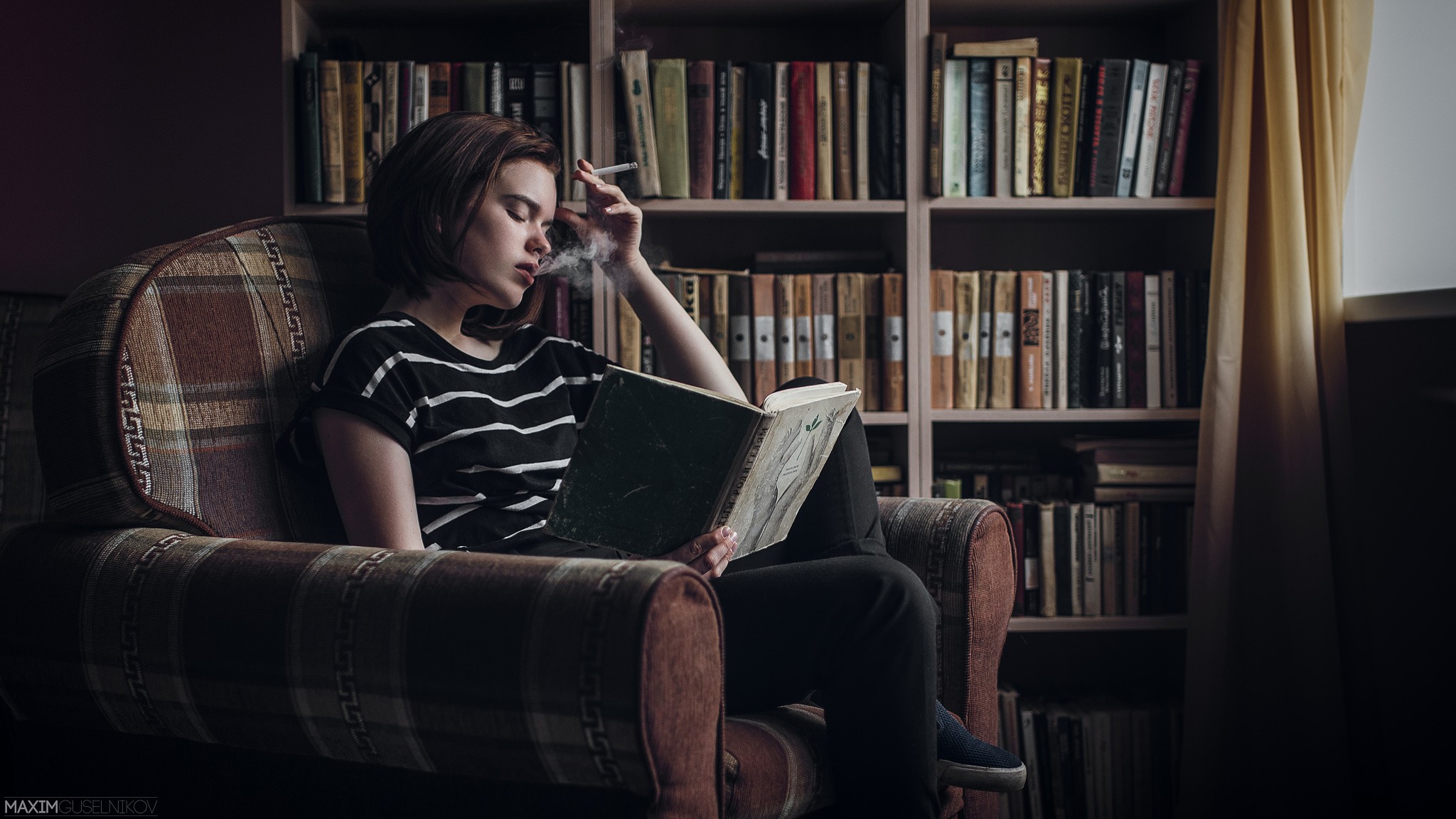 Alina Bazanova reading and smoking in a chair HD Wallpaper