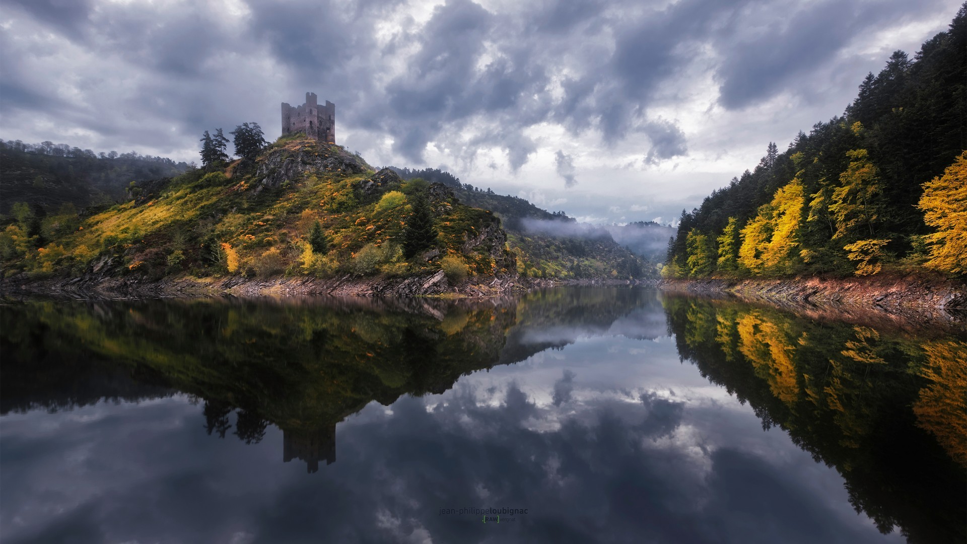Castle on a hill reflected in a lake with autumn trees HD Wallpaper