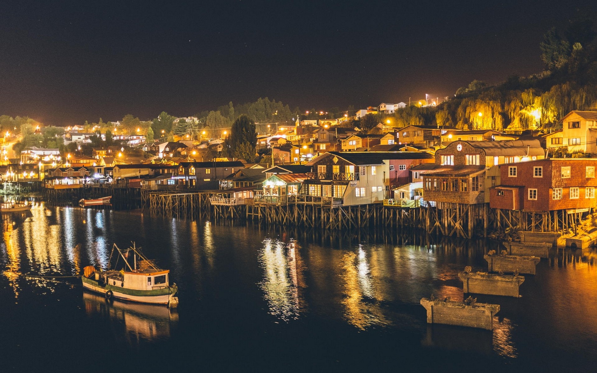 Night view of stilt houses and boats in Chile HD Wallpaper