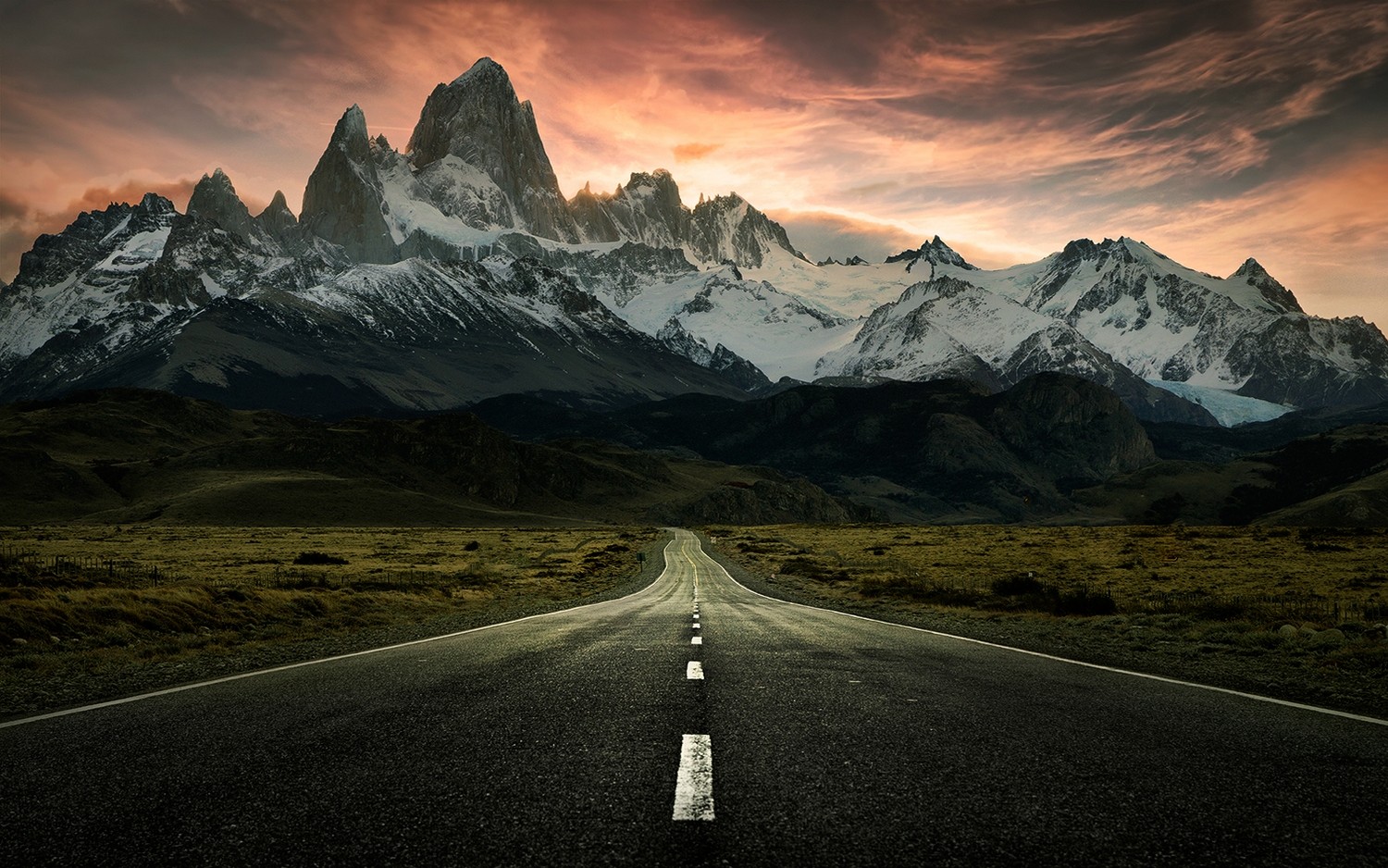 Road leading to snow-capped mountains at sunset HD Wallpaper