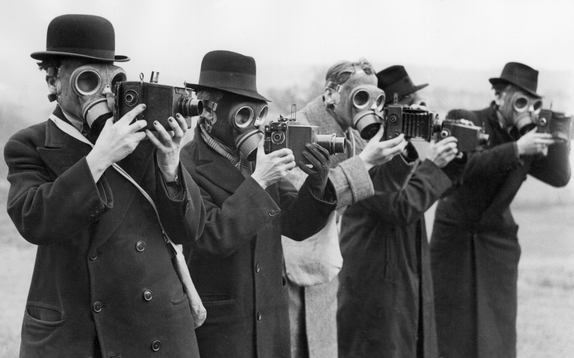 Men in gas masks holding cameras HD Wallpaper