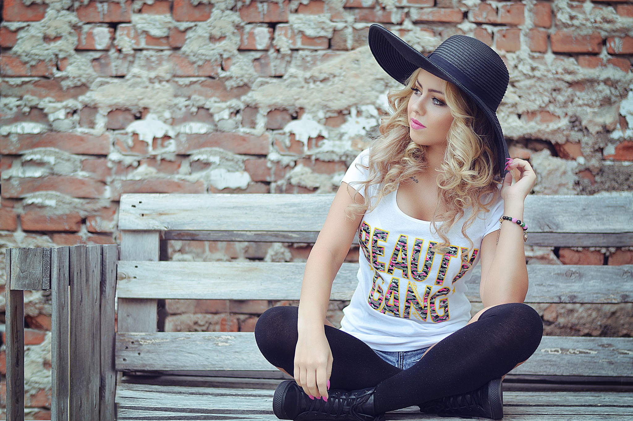 Woman in black hat and white t-shirt sitting on bench HD Wallpaper