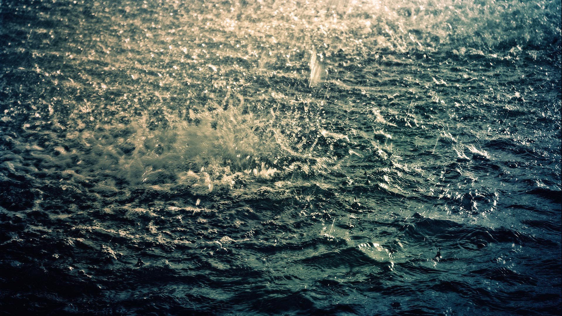 Rain falling on dark, choppy water HD Wallpaper