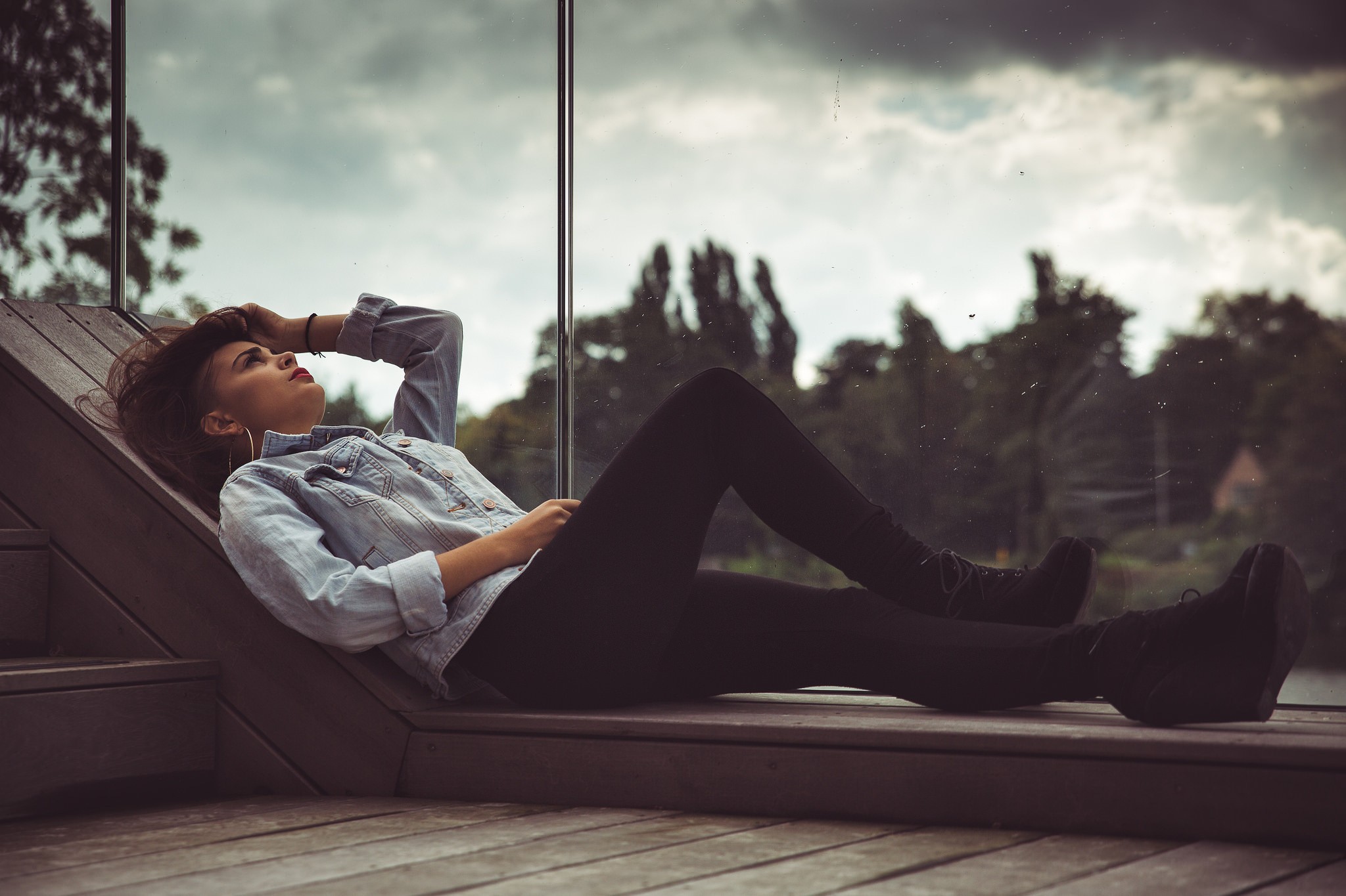 Woman in denim jacket lying on a wooden deck HD Wallpaper