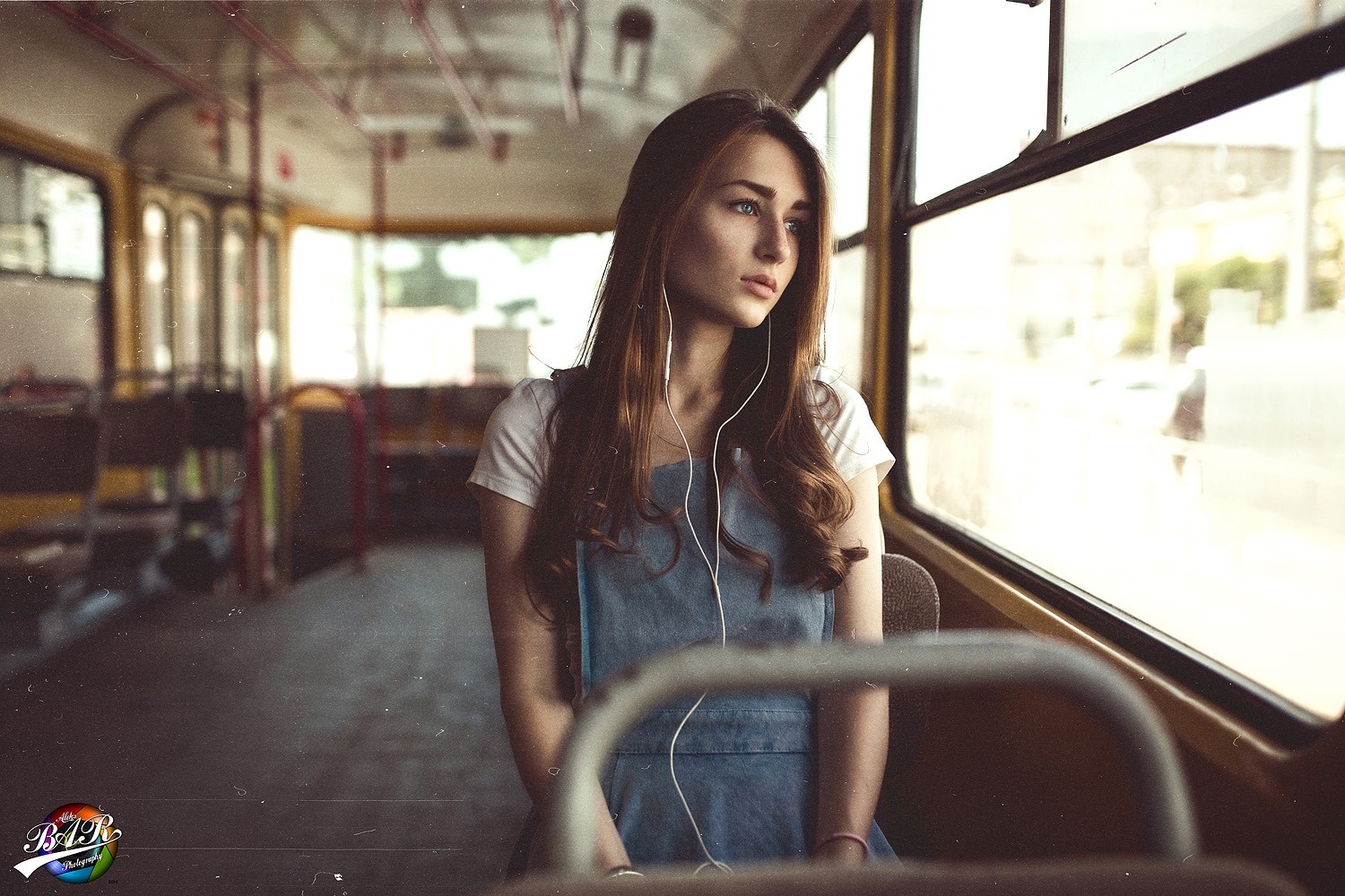 Woman with headphones sitting on a bus HD Wallpaper