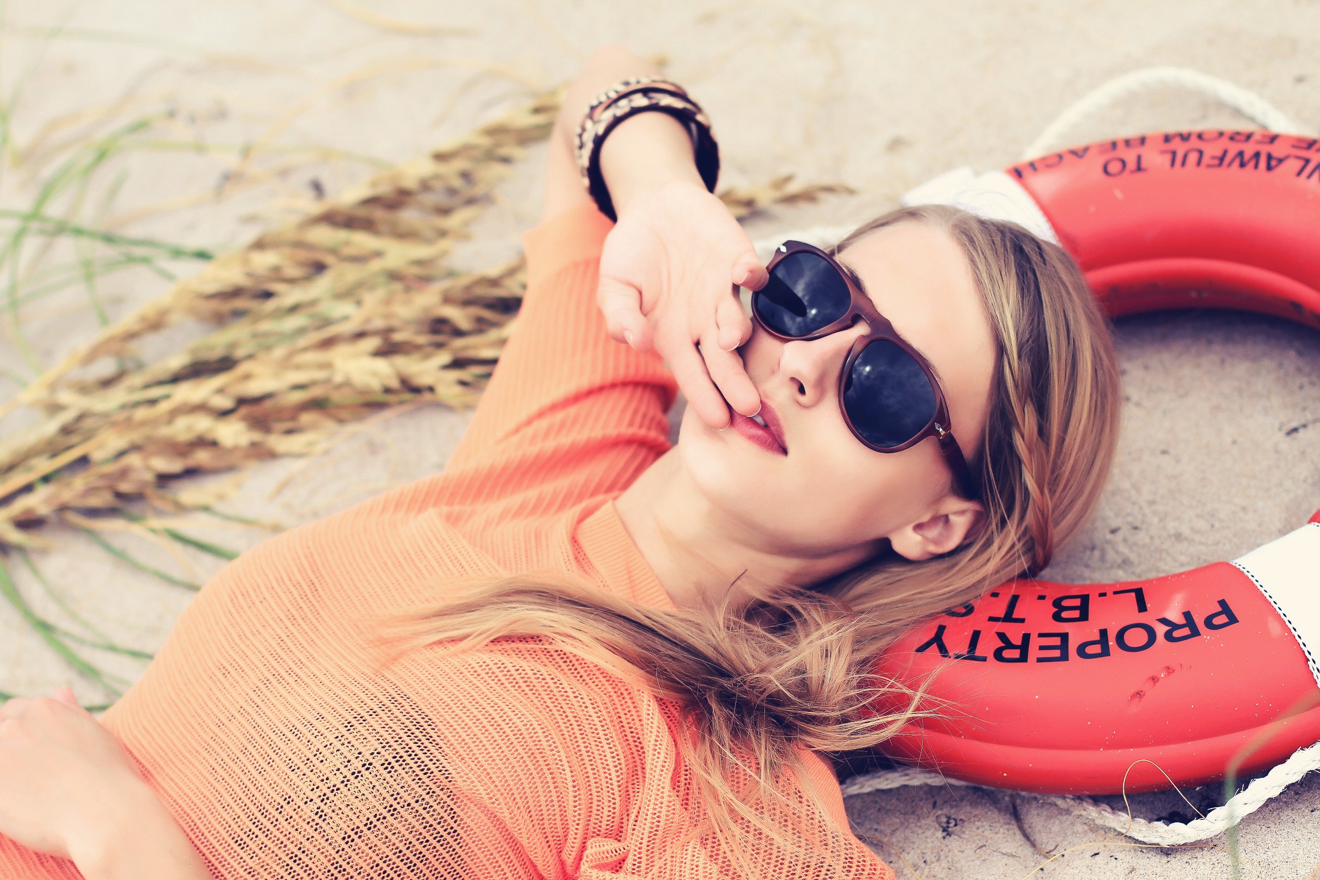 Woman in sunglasses lying on the beach HD Wallpaper