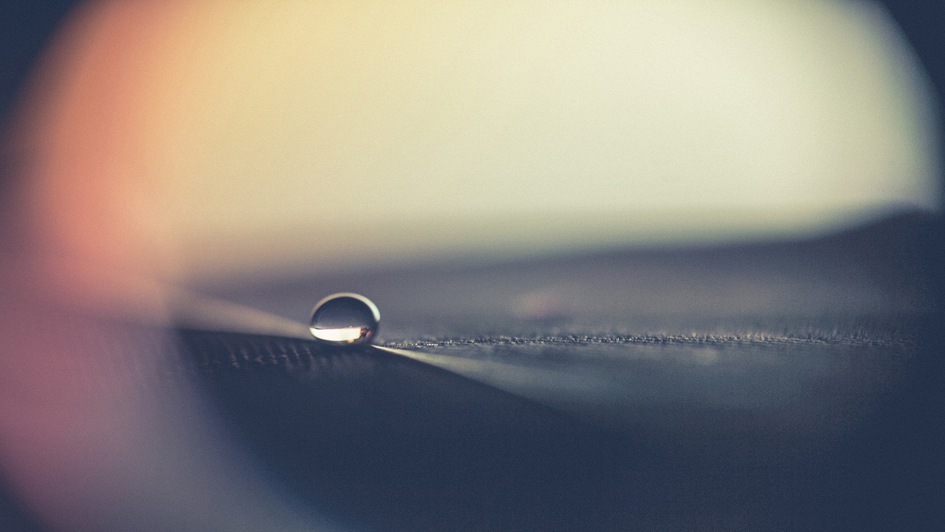 Macro shot of a single water drop on a surface HD Wallpaper