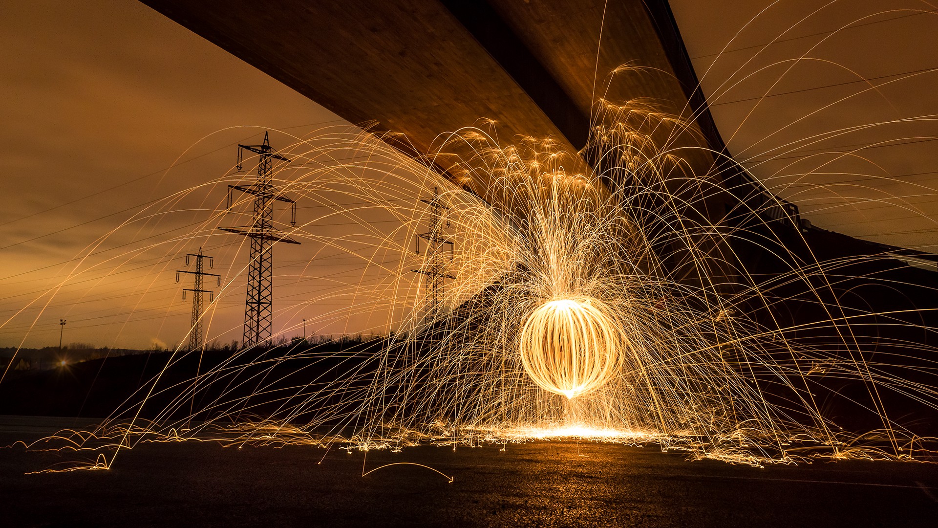 Long exposure photography of steel wool spinning under a bridge HD Wallpaper