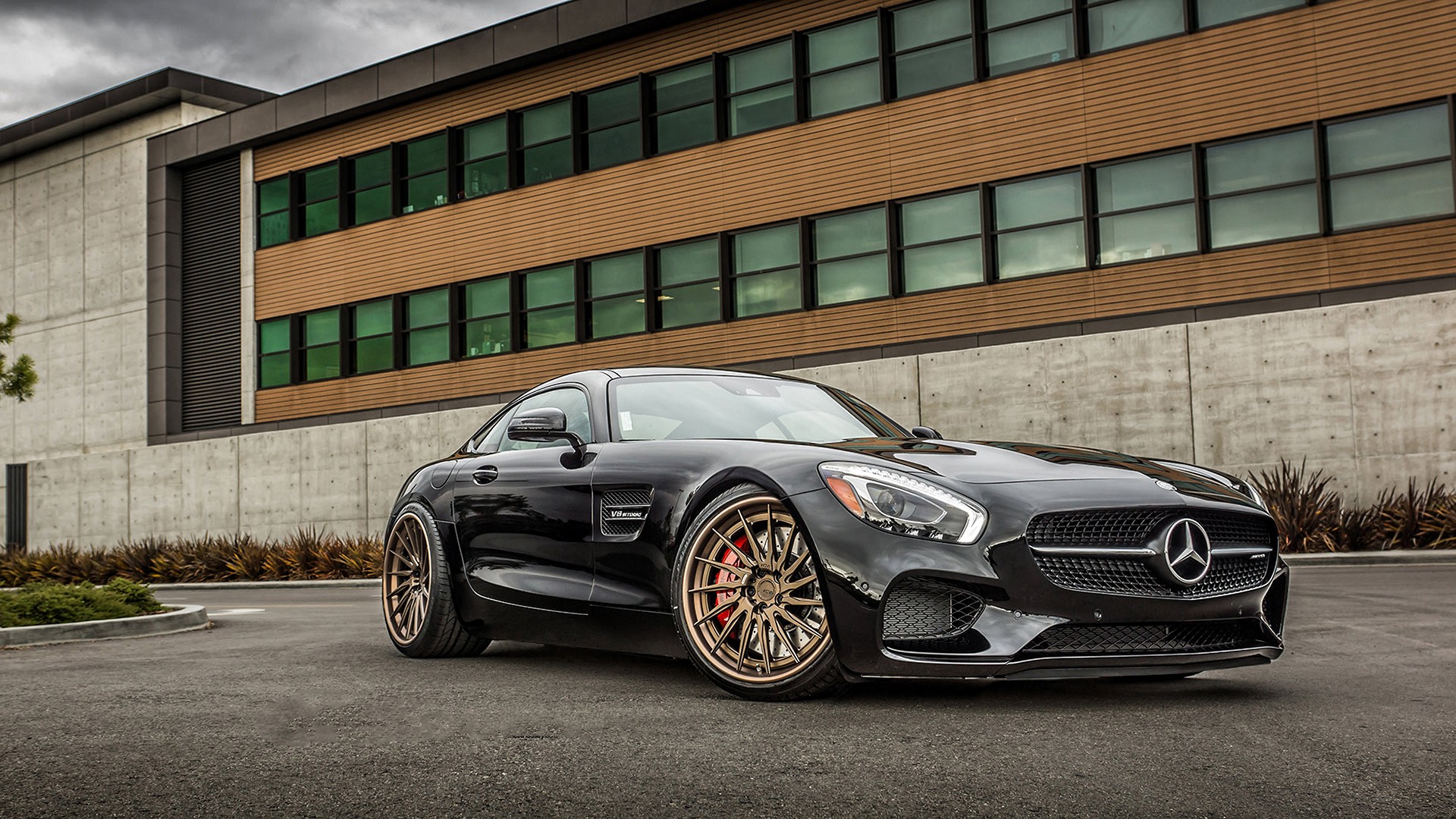 Black Mercedes-AMG GT parked in front of a modern building HD Wallpaper