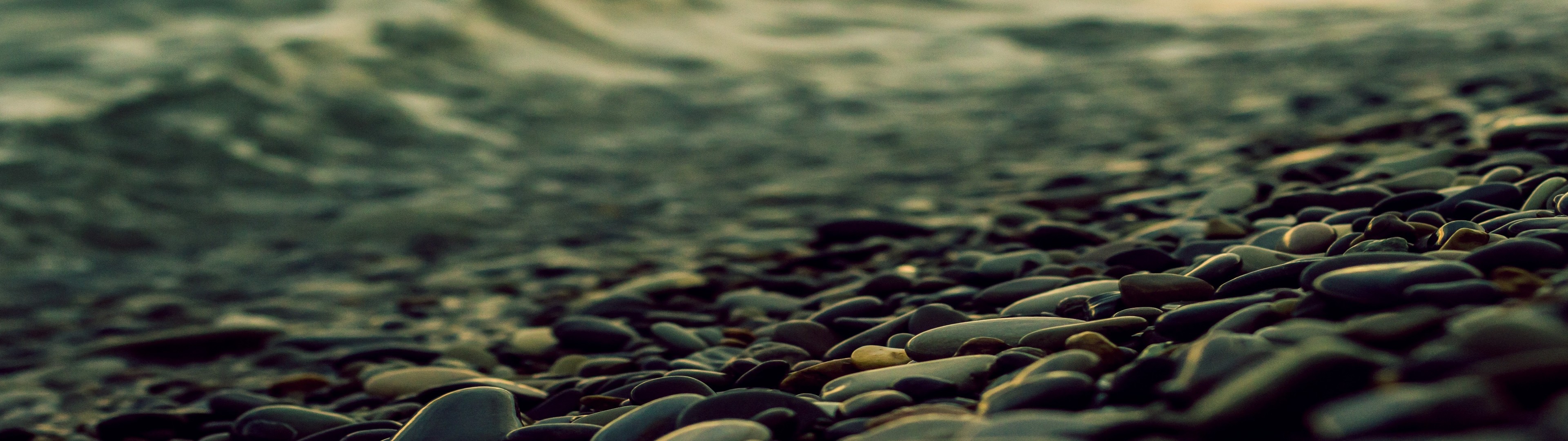 Close-up of wet stones on a beach with waves HD Wallpaper