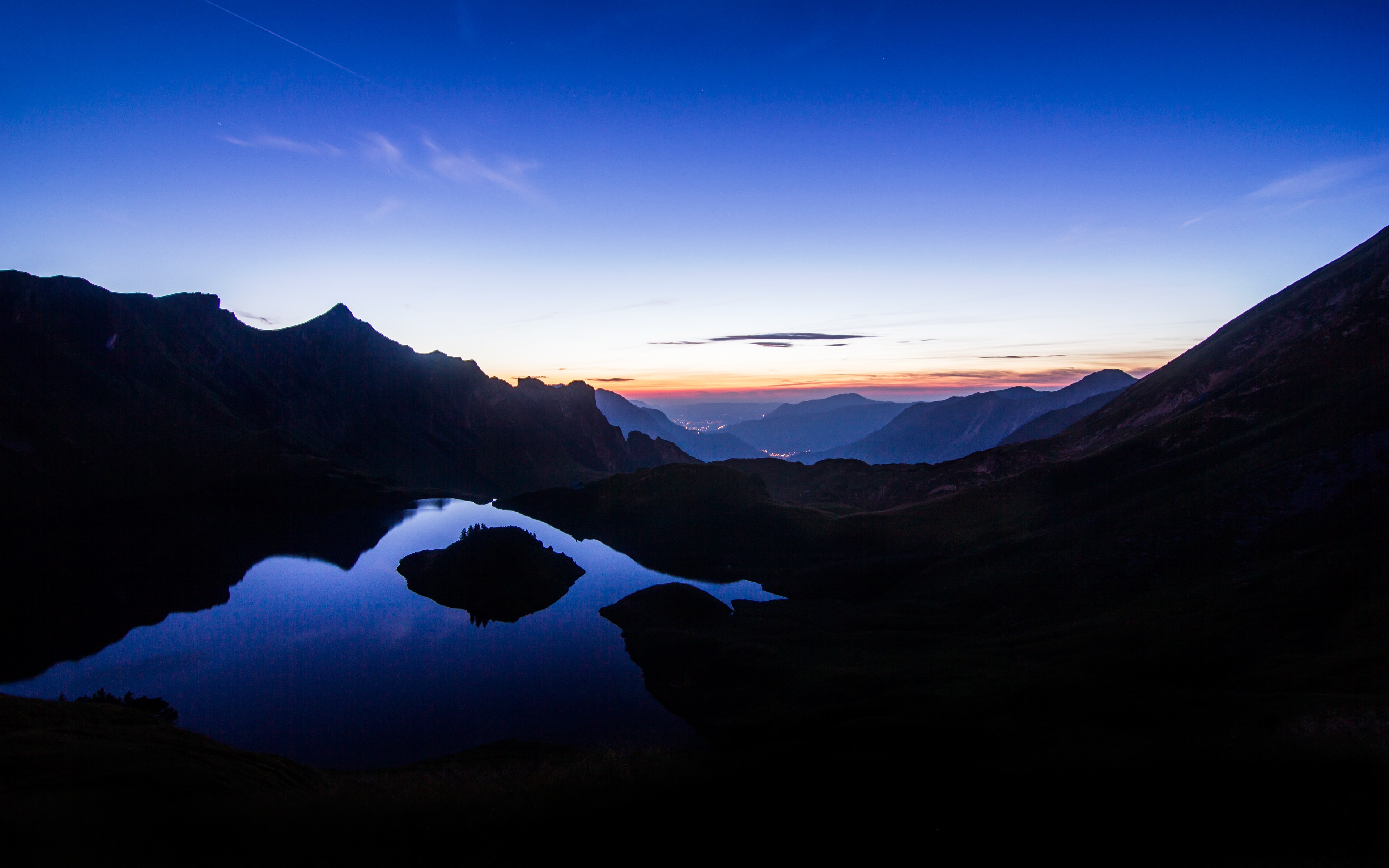 Mountain lake at twilight with distant valley lights HD Wallpaper