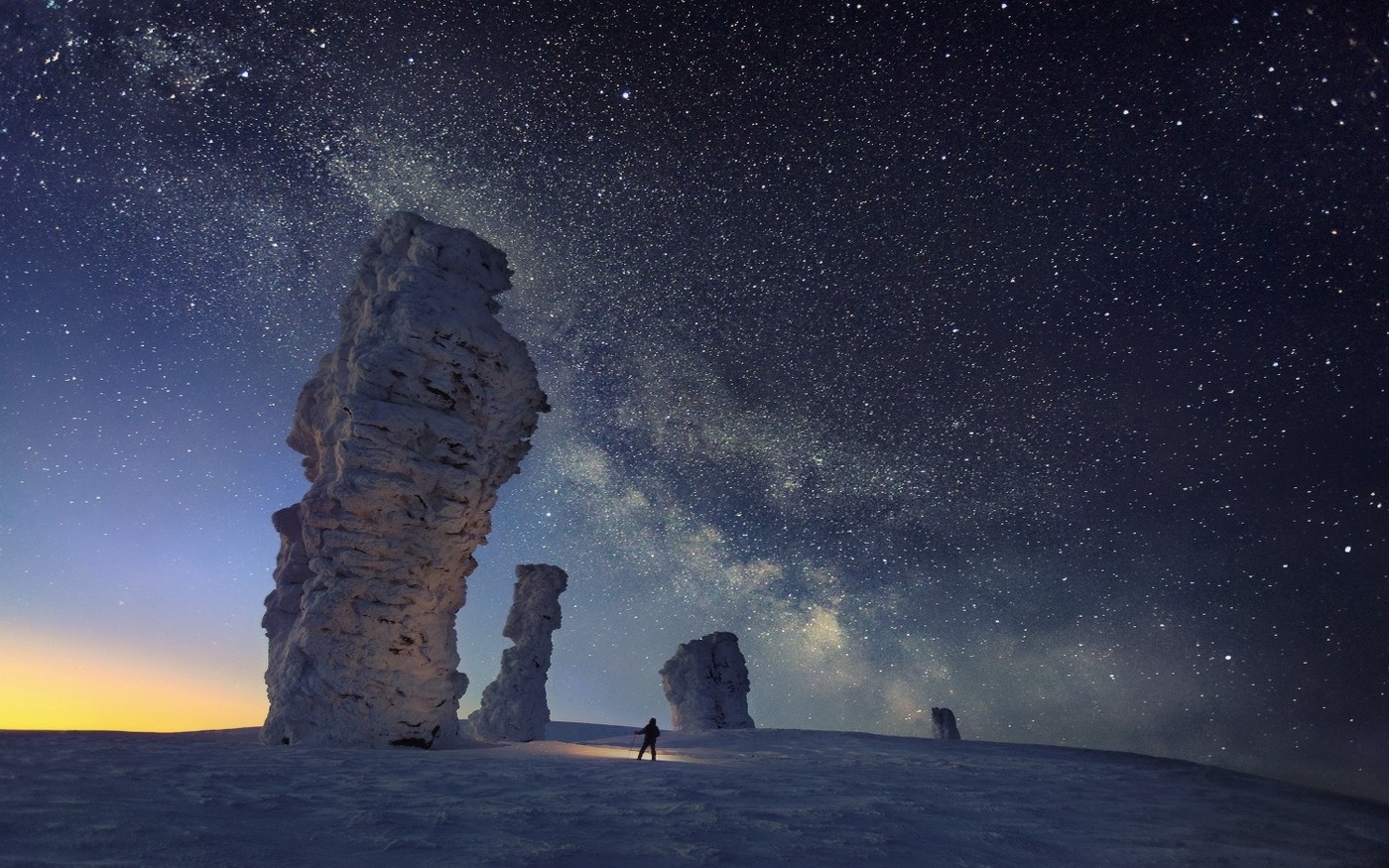 Starry night over rock formations in winter landscape HD Wallpaper