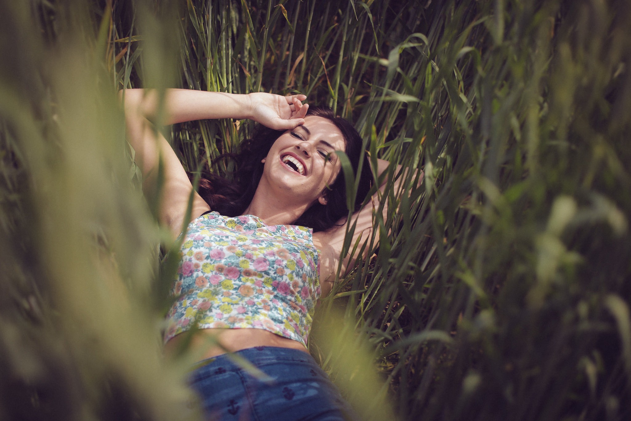 Aurela Skandaj laughing in tall grass HD Wallpaper