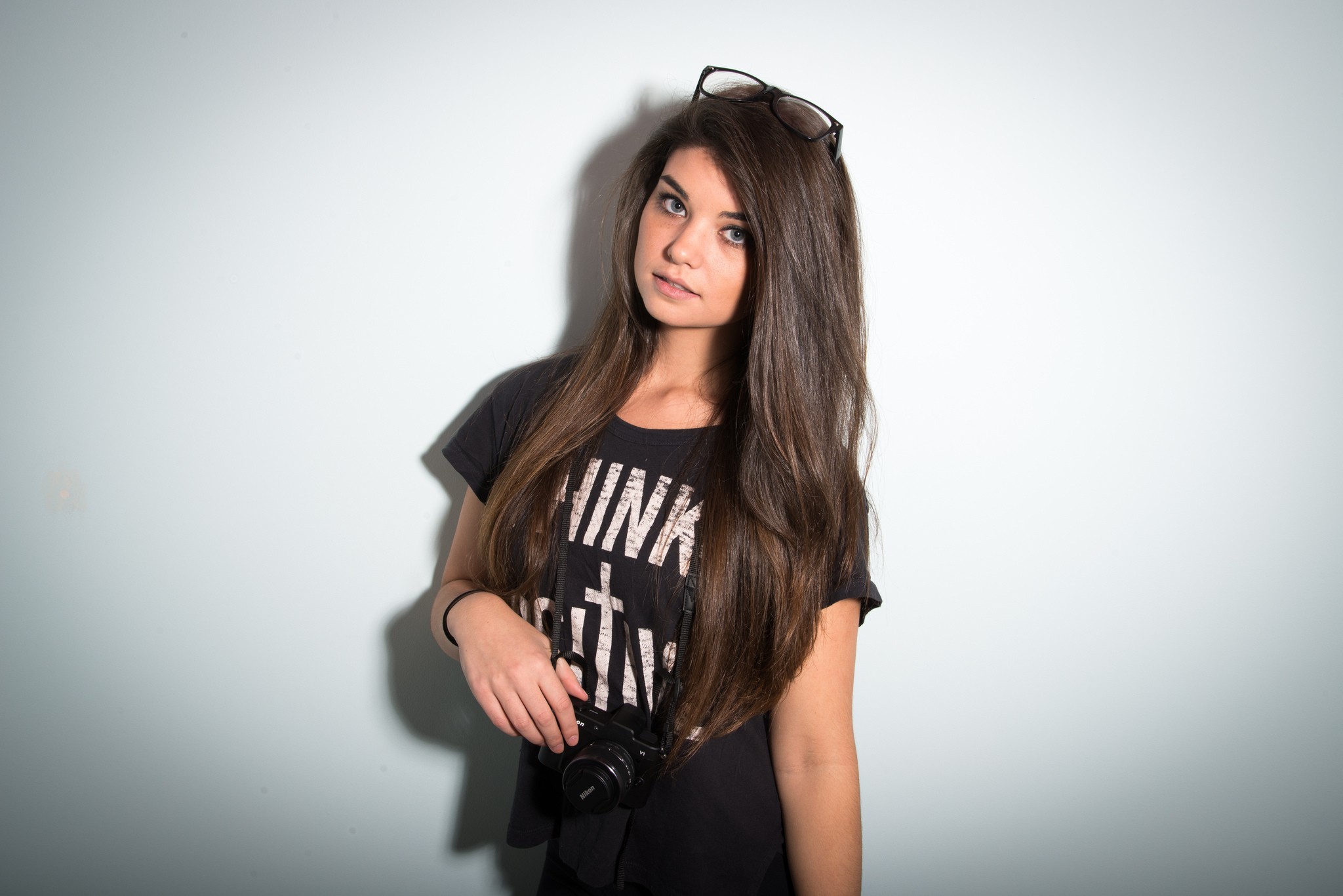Woman with long brown hair and glasses holding a camera HD Wallpaper