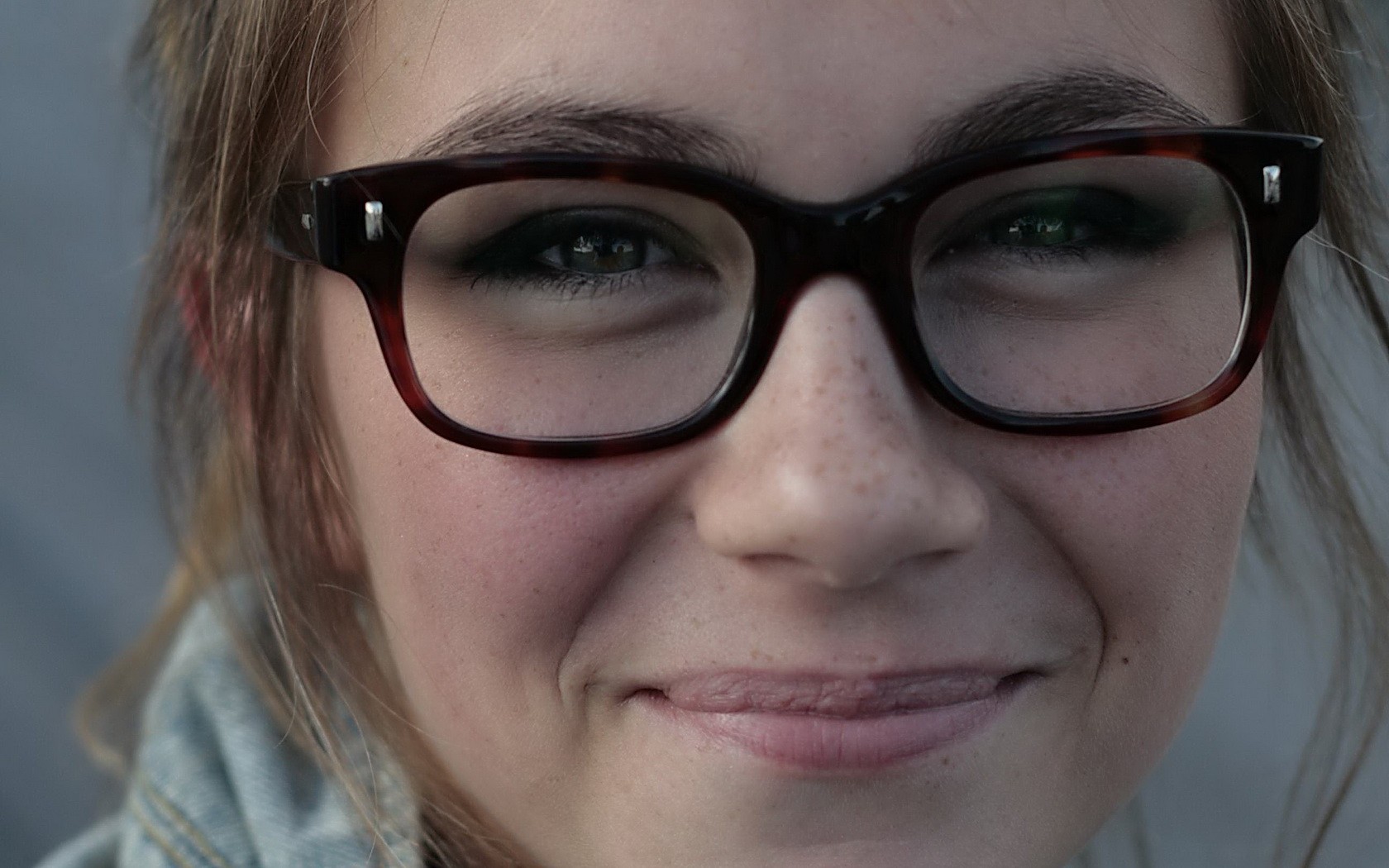 Close-up portrait of a young woman wearing glasses HD Wallpaper