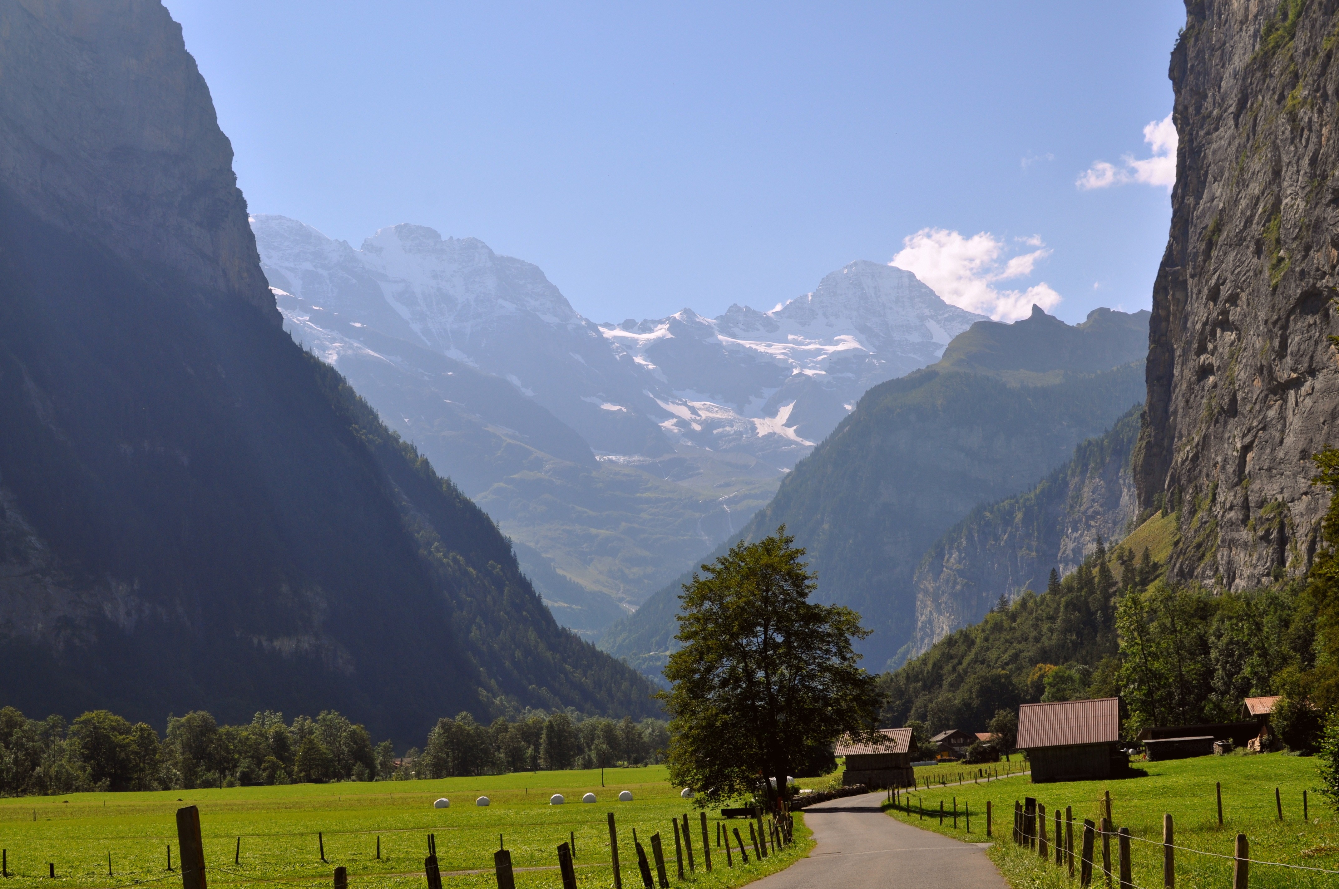Valley with snow-capped mountains and traditional houses HD Wallpaper