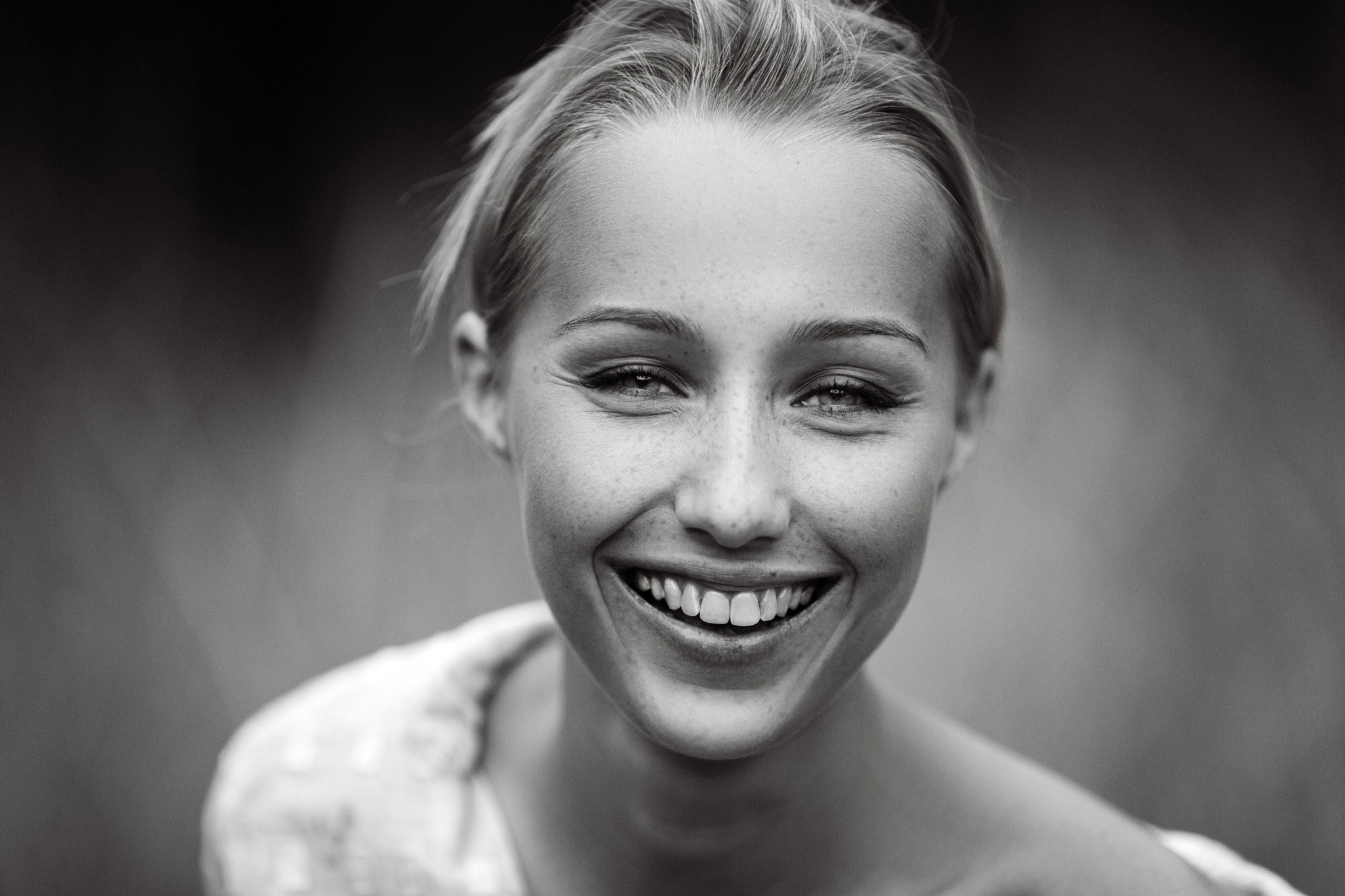 Monochrome portrait of a smiling woman with freckles HD Wallpaper