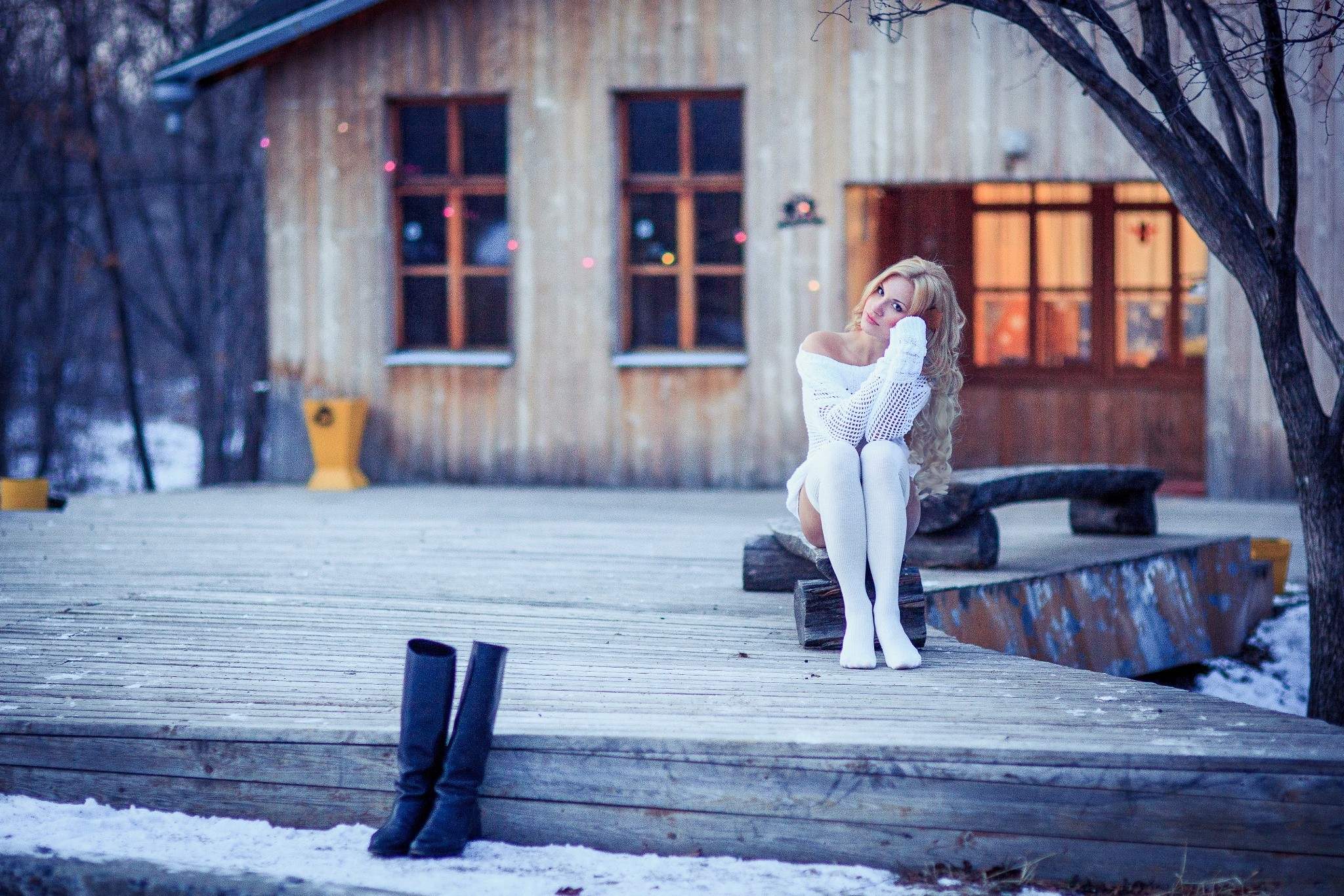 Woman in white clothing sitting on a wooden deck in winter HD Wallpaper