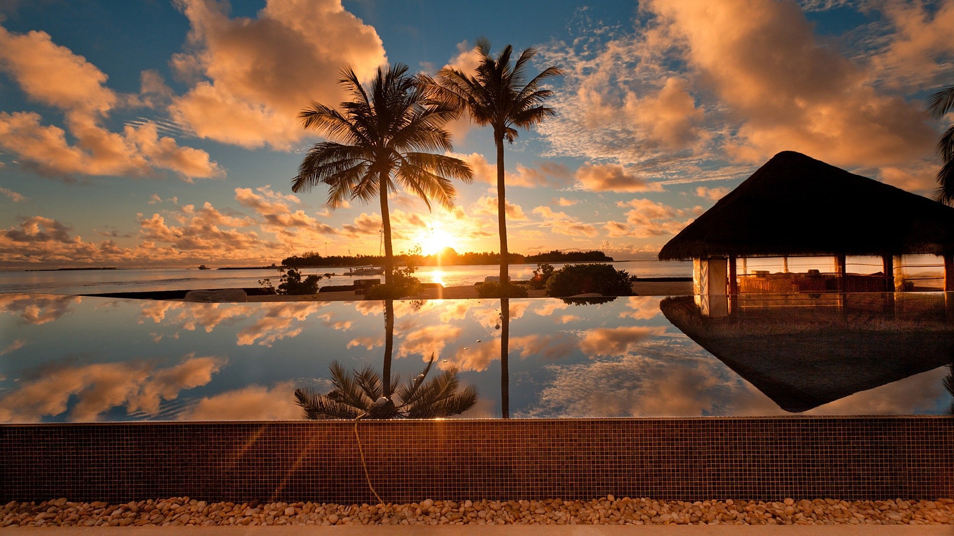 Tropical sunset over ocean with infinity pool and hut HD Wallpaper