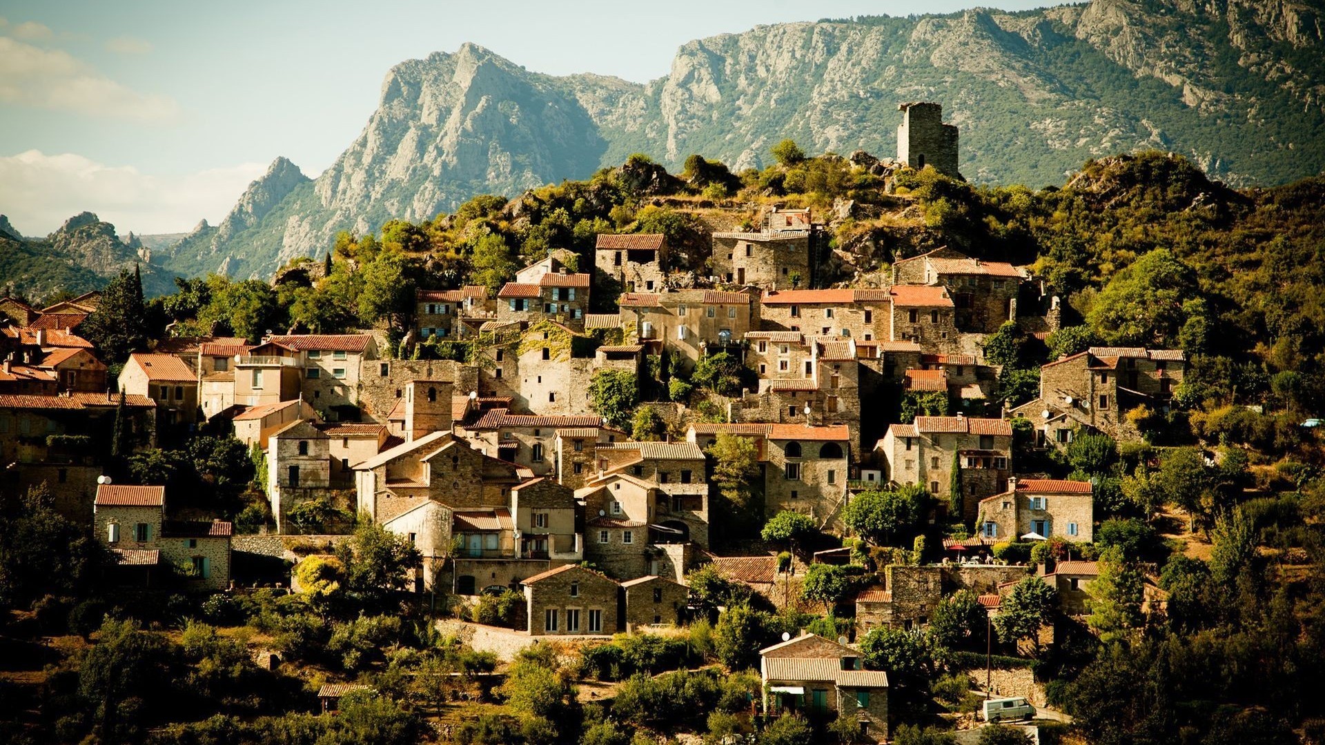 Village on a mountainside with a tower HD Wallpaper