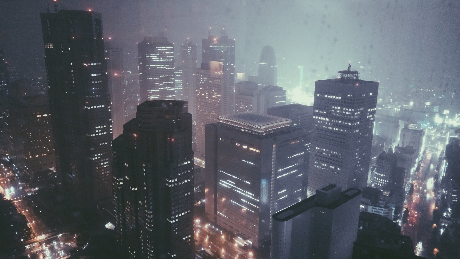 Rainy city skyline with skyscrapers at night HD Wallpaper