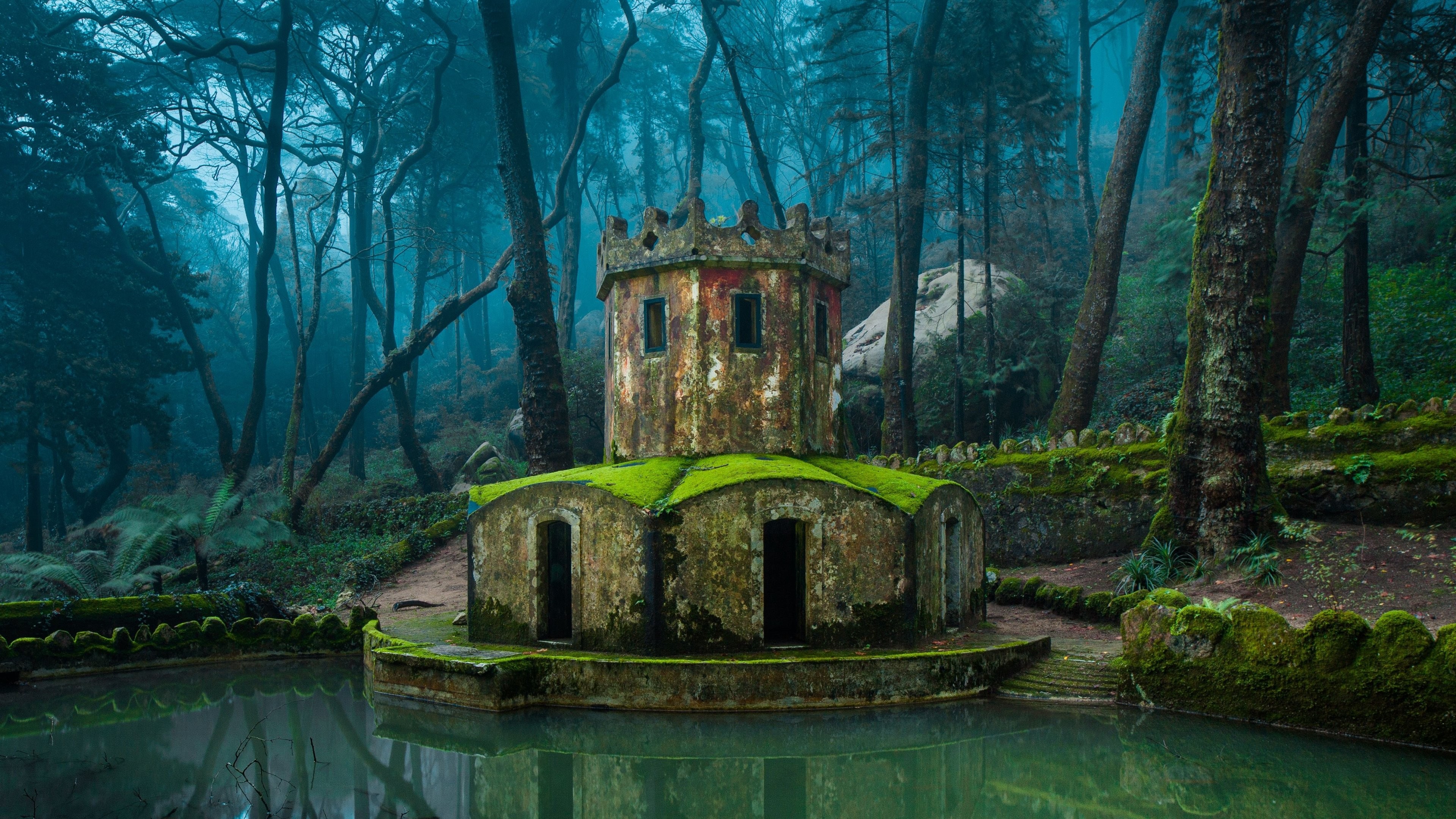 Old moss-covered tower by a lake in a foggy forest HD Wallpaper
