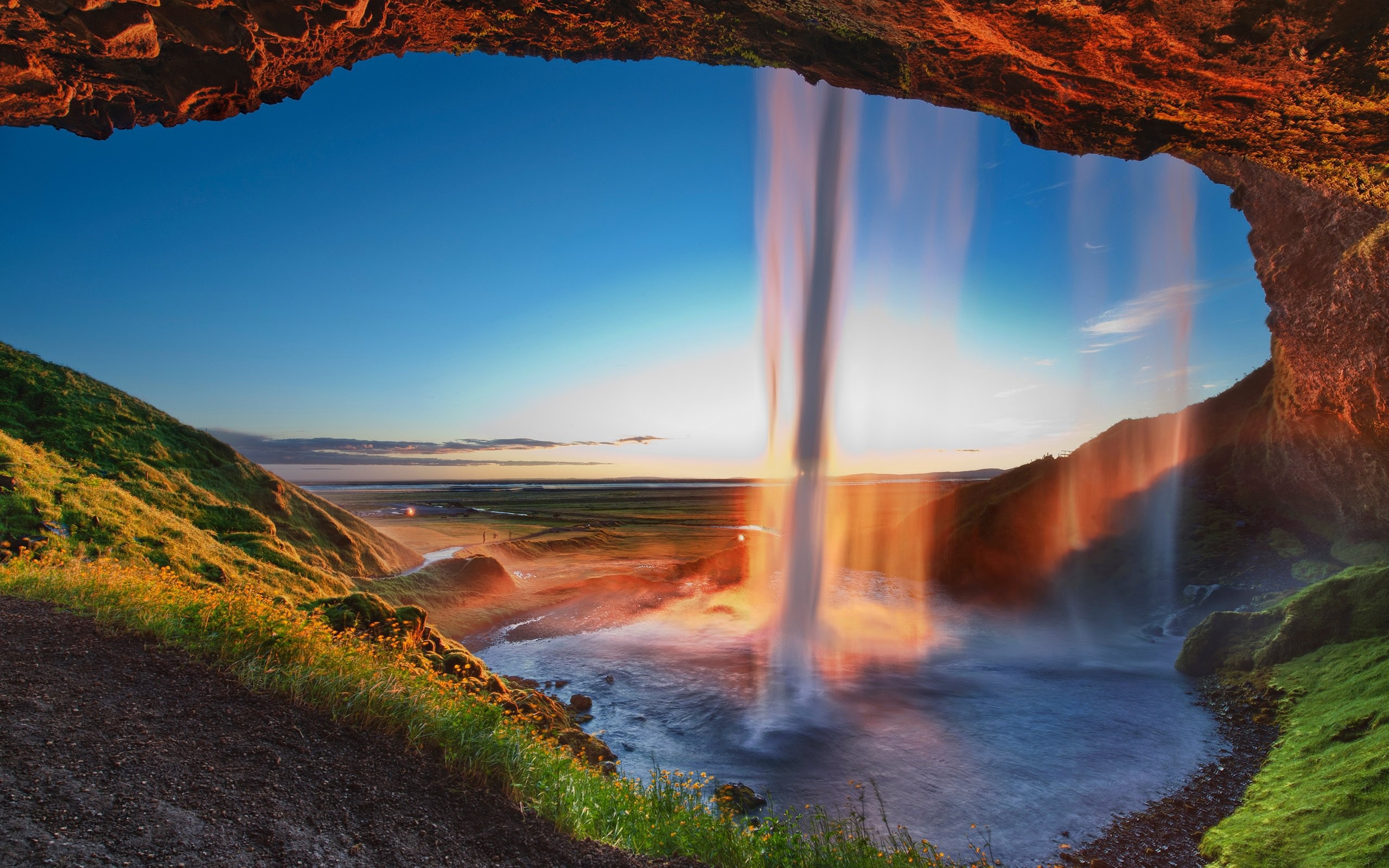 Waterfall seen from a cave at sunset HD Wallpaper