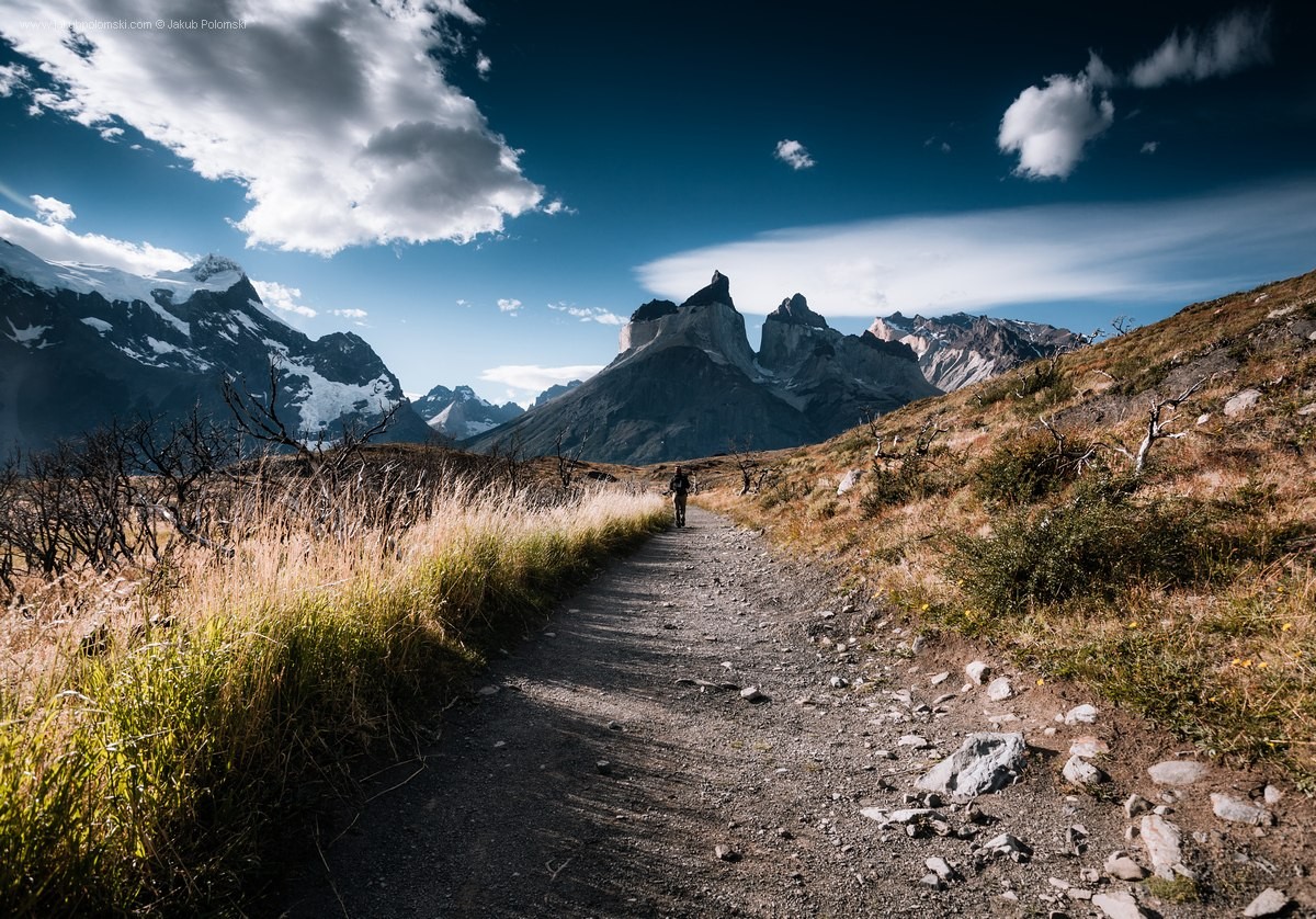 Man walking on a path towards mountains HD Wallpaper