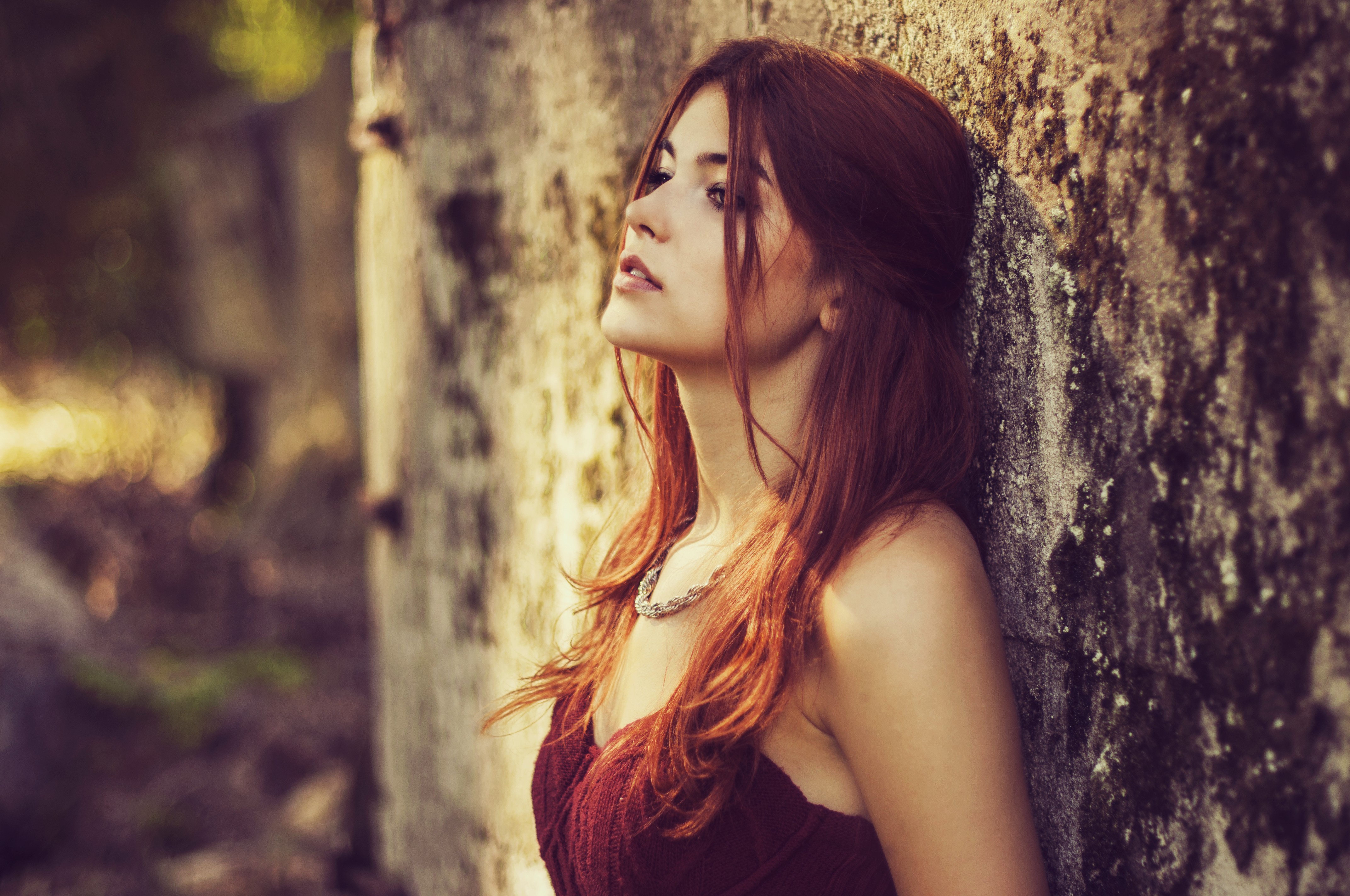 Woman with long red hair leaning against a wall HD Wallpaper