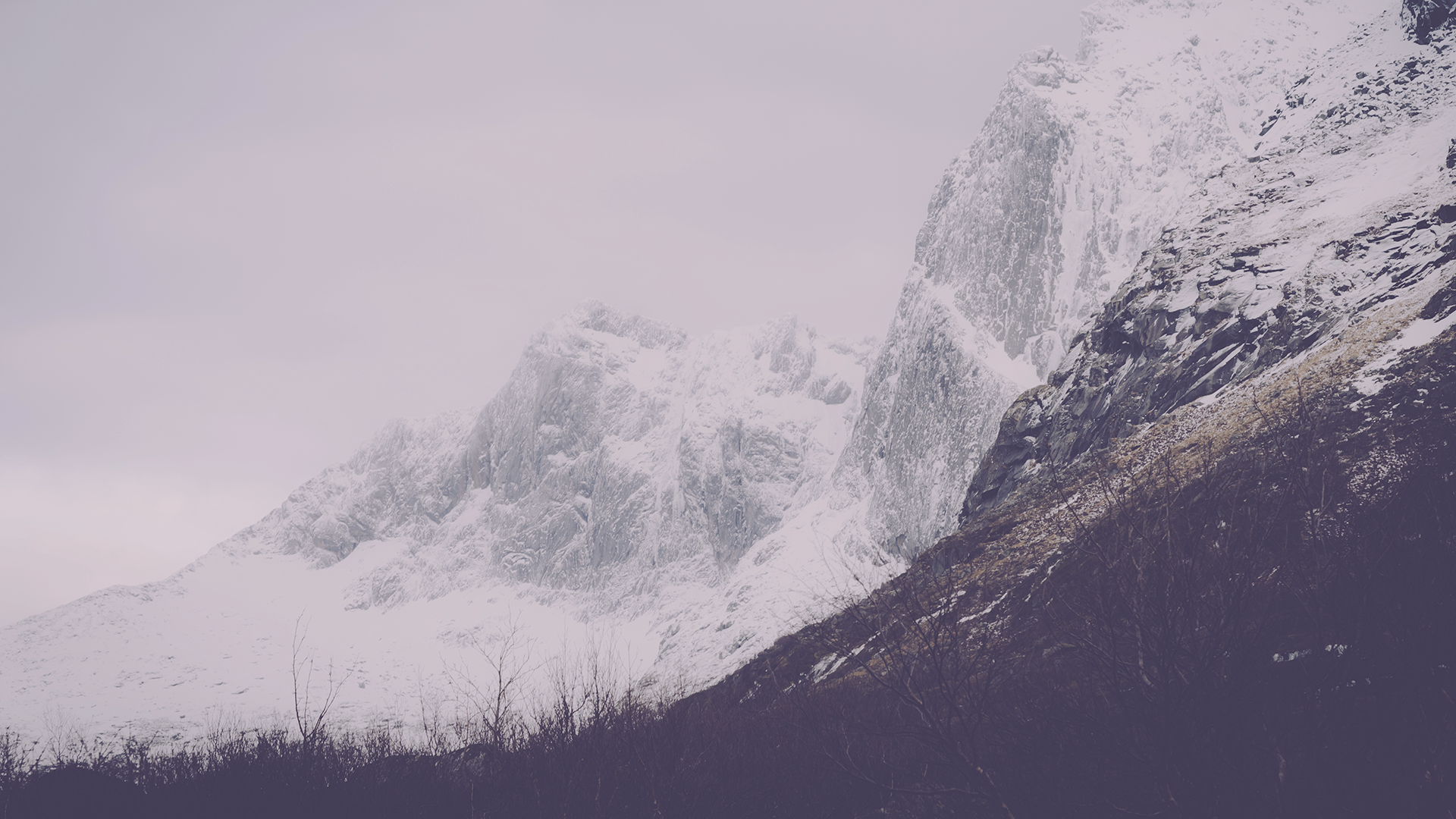Snow-covered mountains under a cloudy sky HD Wallpaper