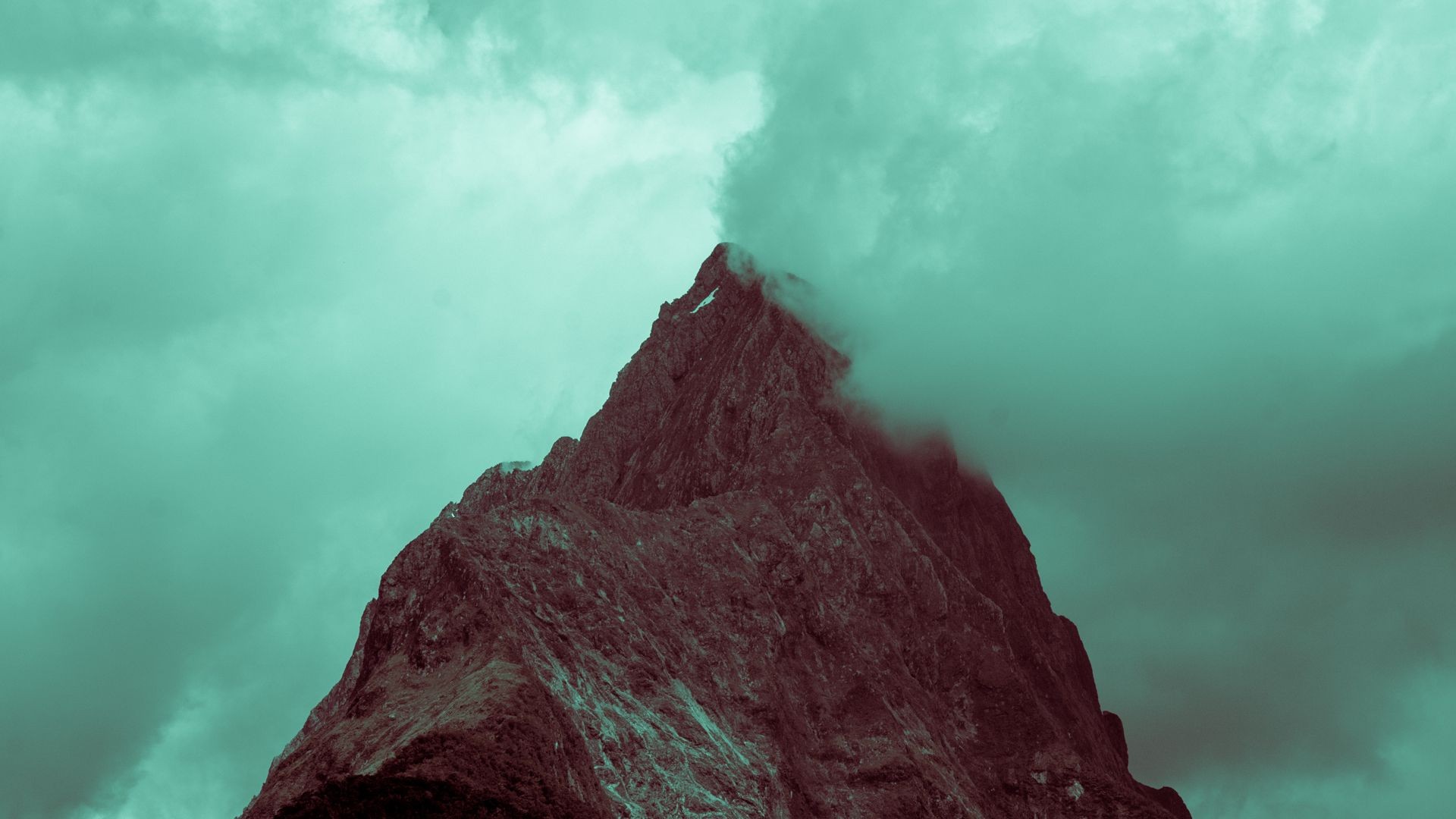 Jagged mountain peak shrouded in mist HD Wallpaper