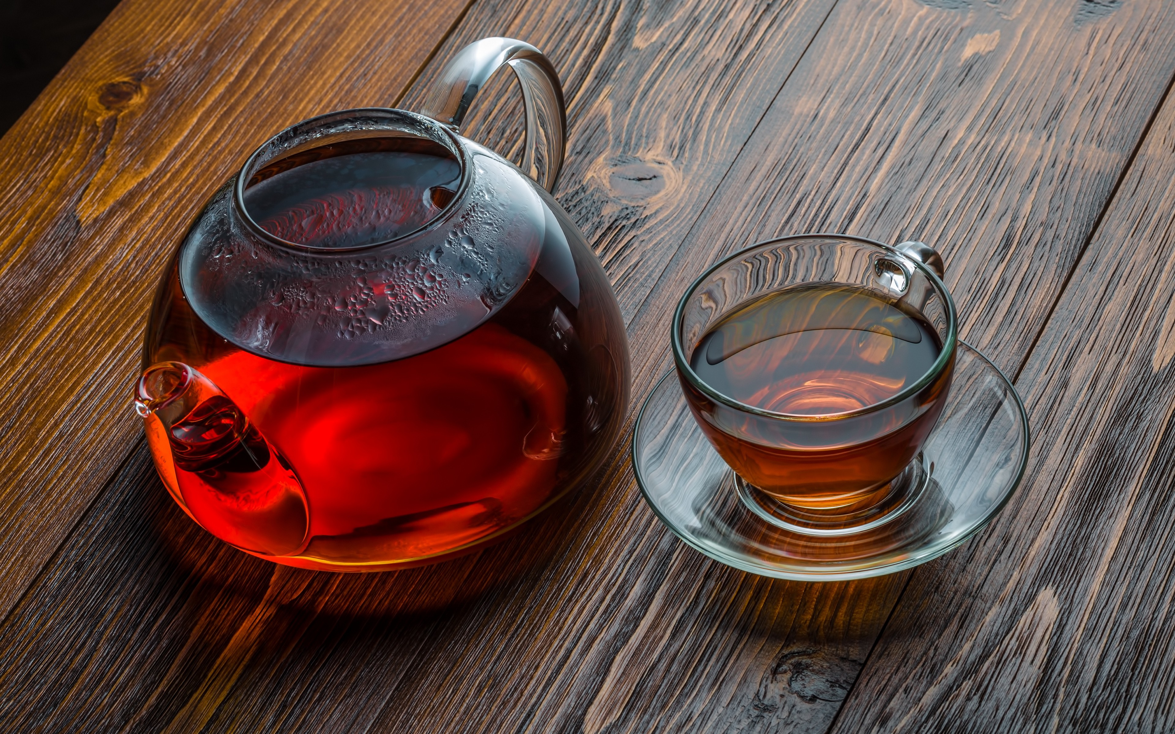 Glass teapot and cup filled with tea HD Wallpaper