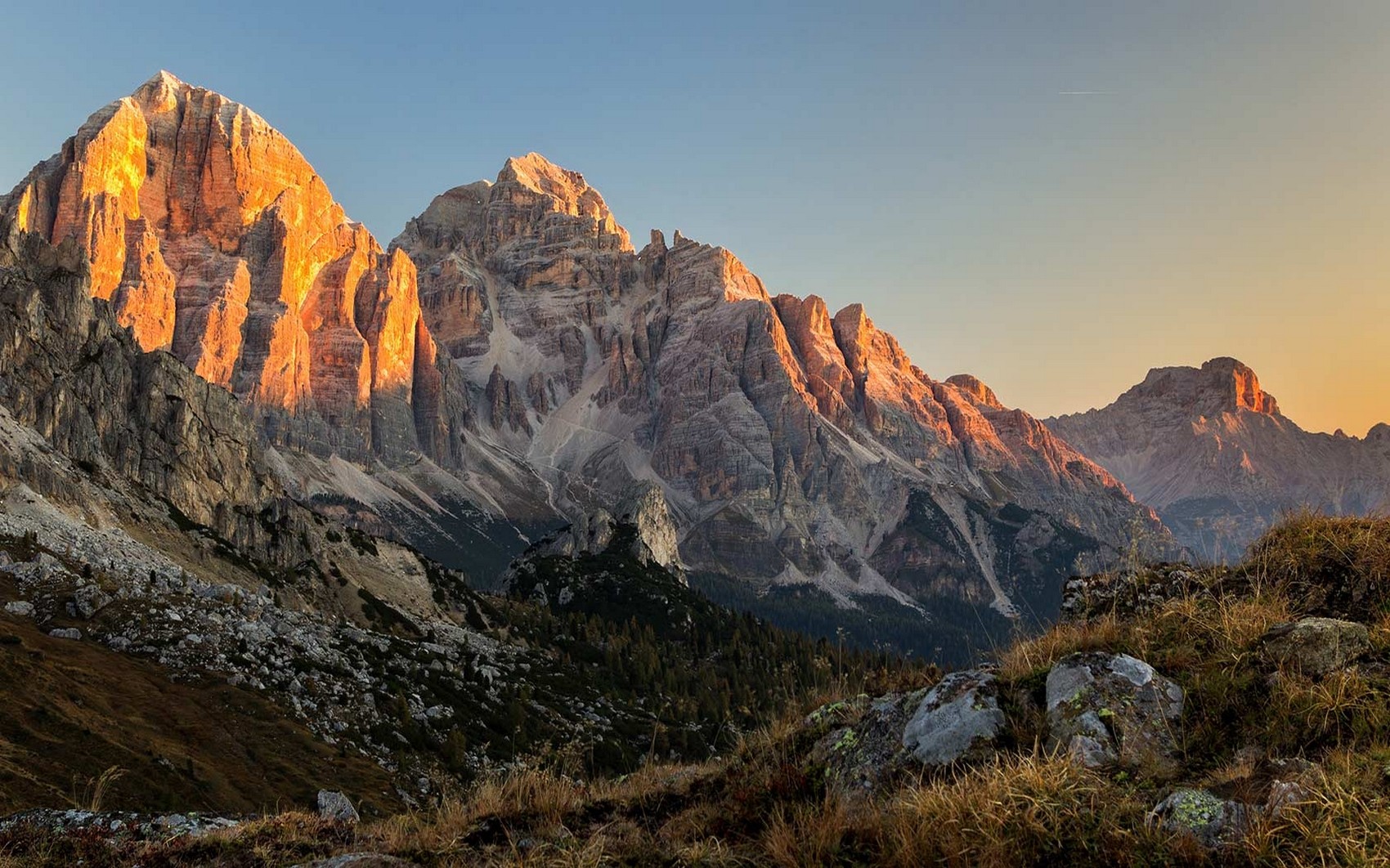 Golden hour illuminates the majestic Dolomites mountain range HD Wallpaper