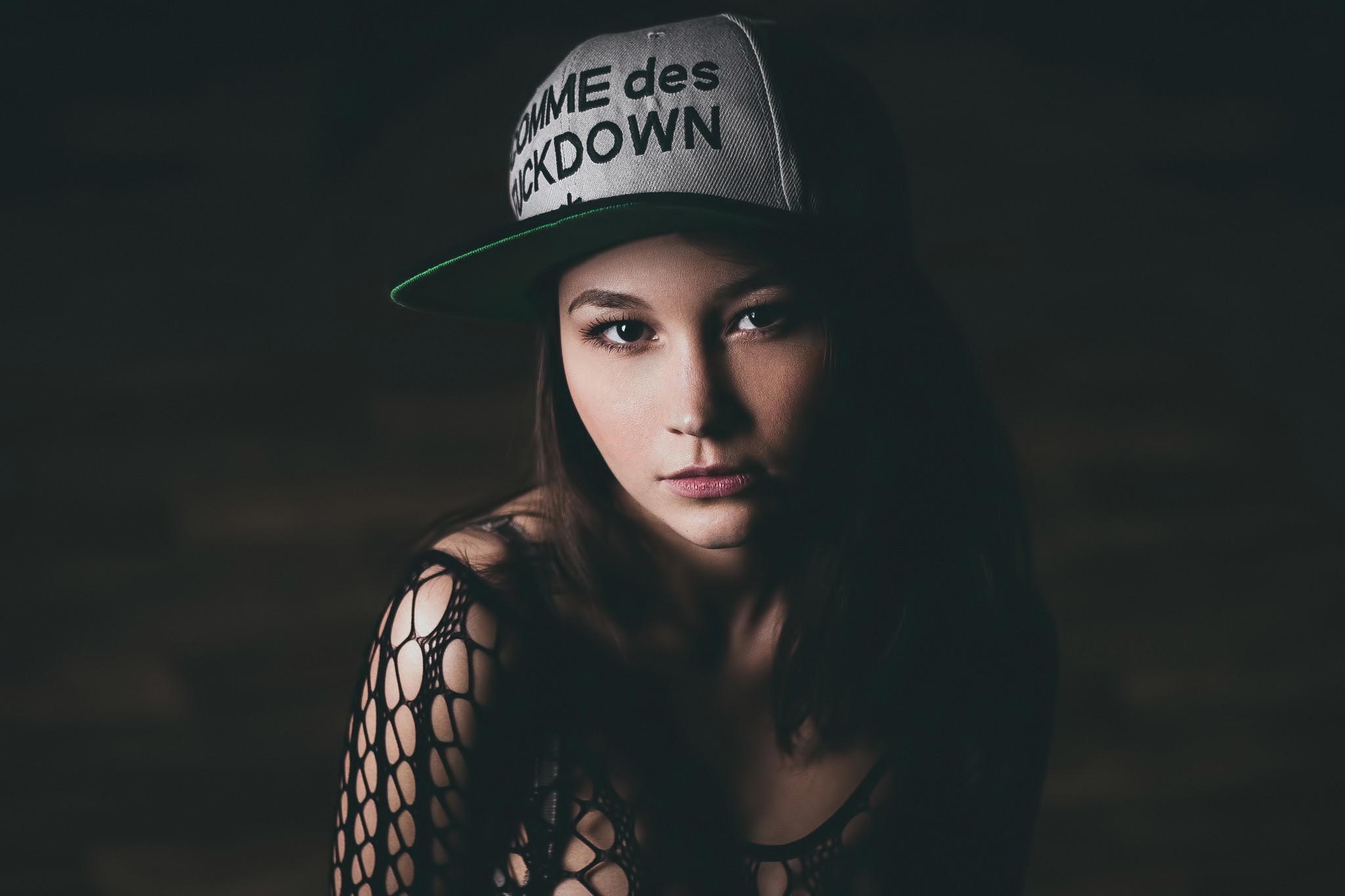 Woman wearing a cap and fishnet top HD Wallpaper