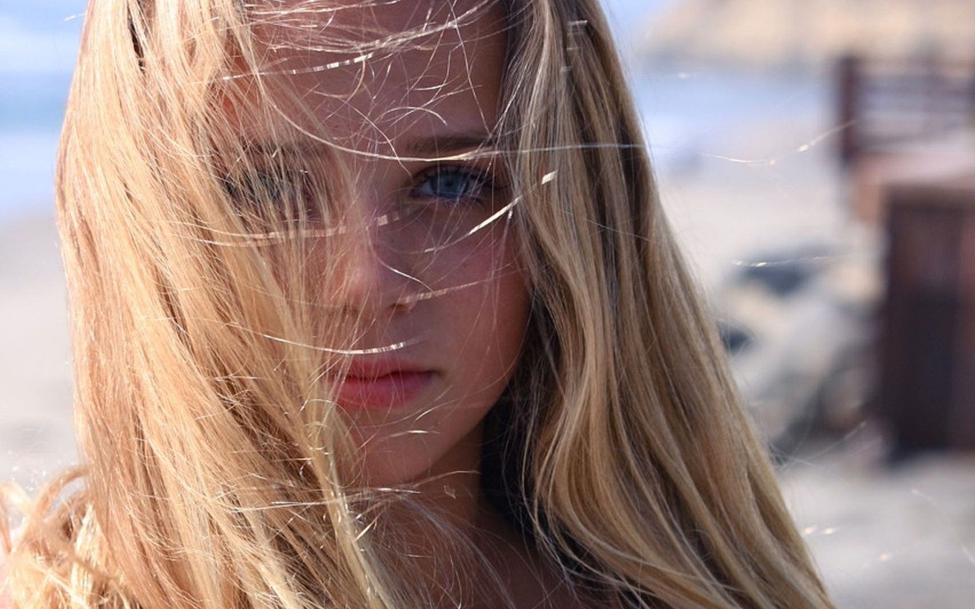 Young woman with blonde hair blowing in the wind HD Wallpaper