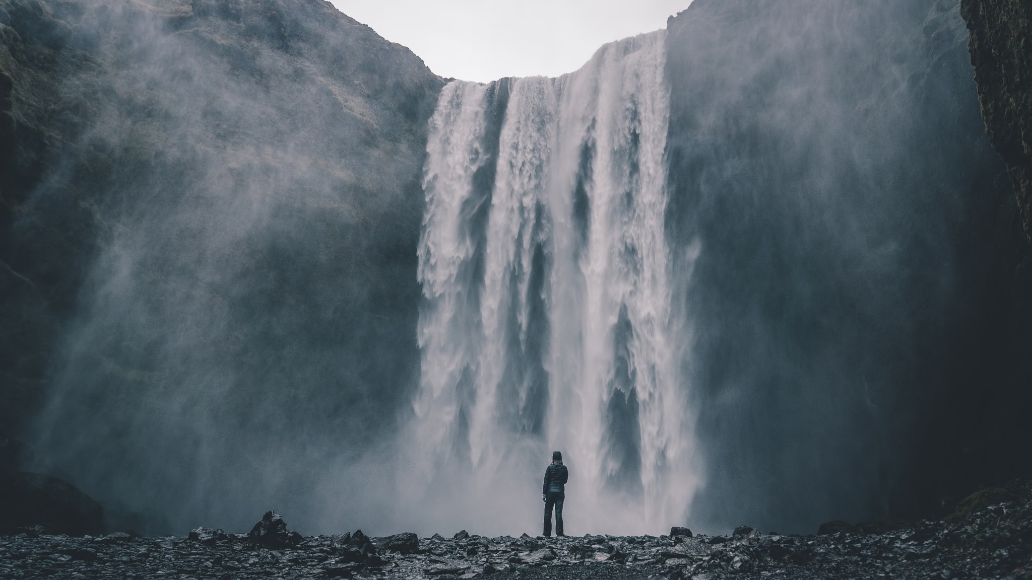 Man standing in front of a large waterfall HD Wallpaper