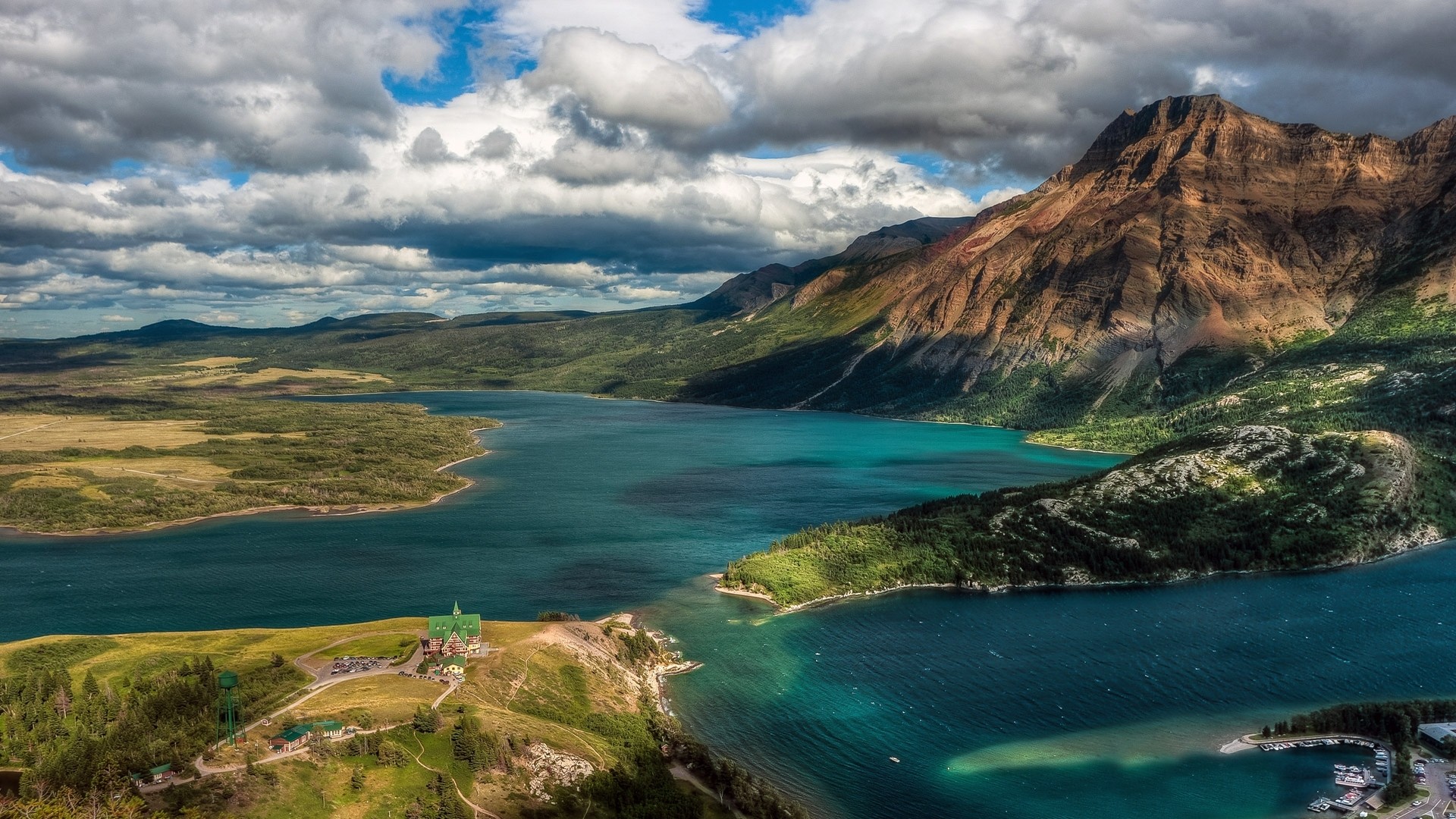 Turquoise lake and mountains with a historic building HD Wallpaper