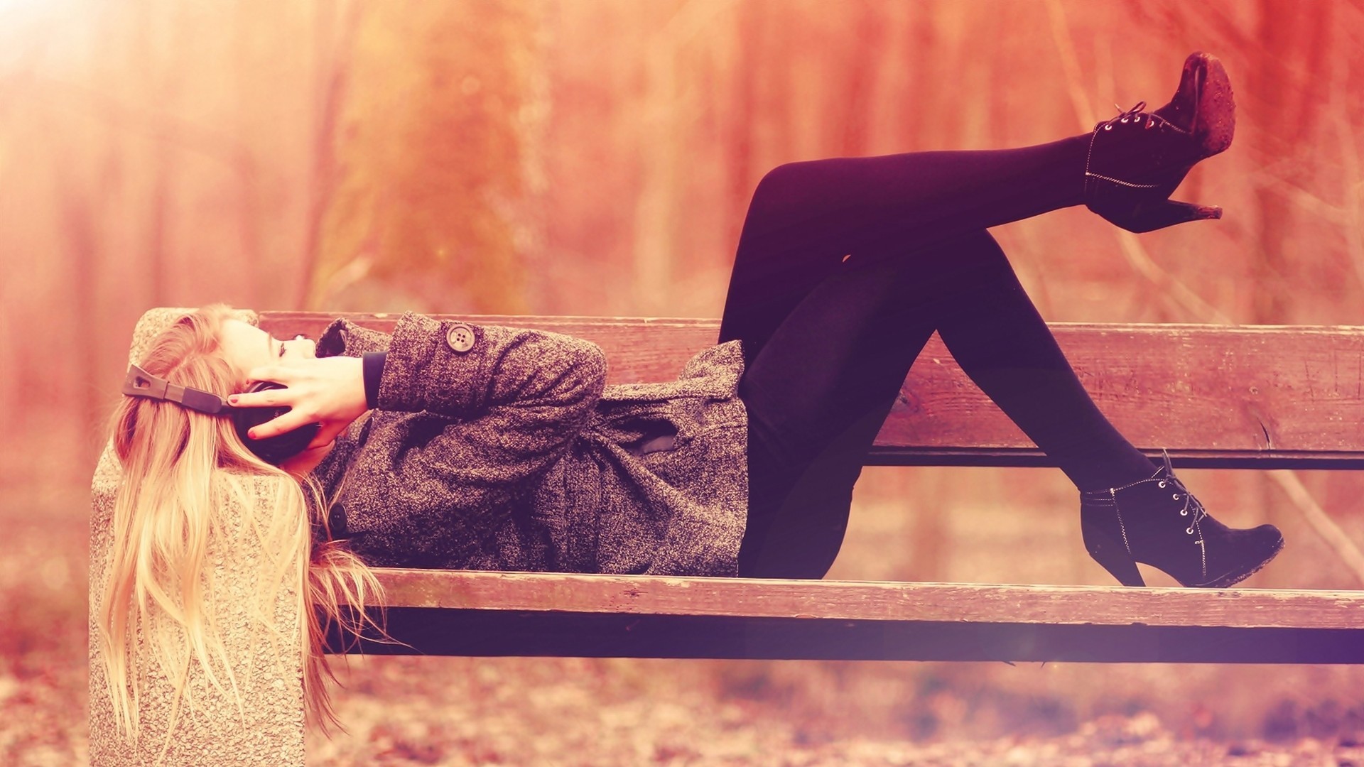 Blonde woman listening to music on a bench HD Wallpaper