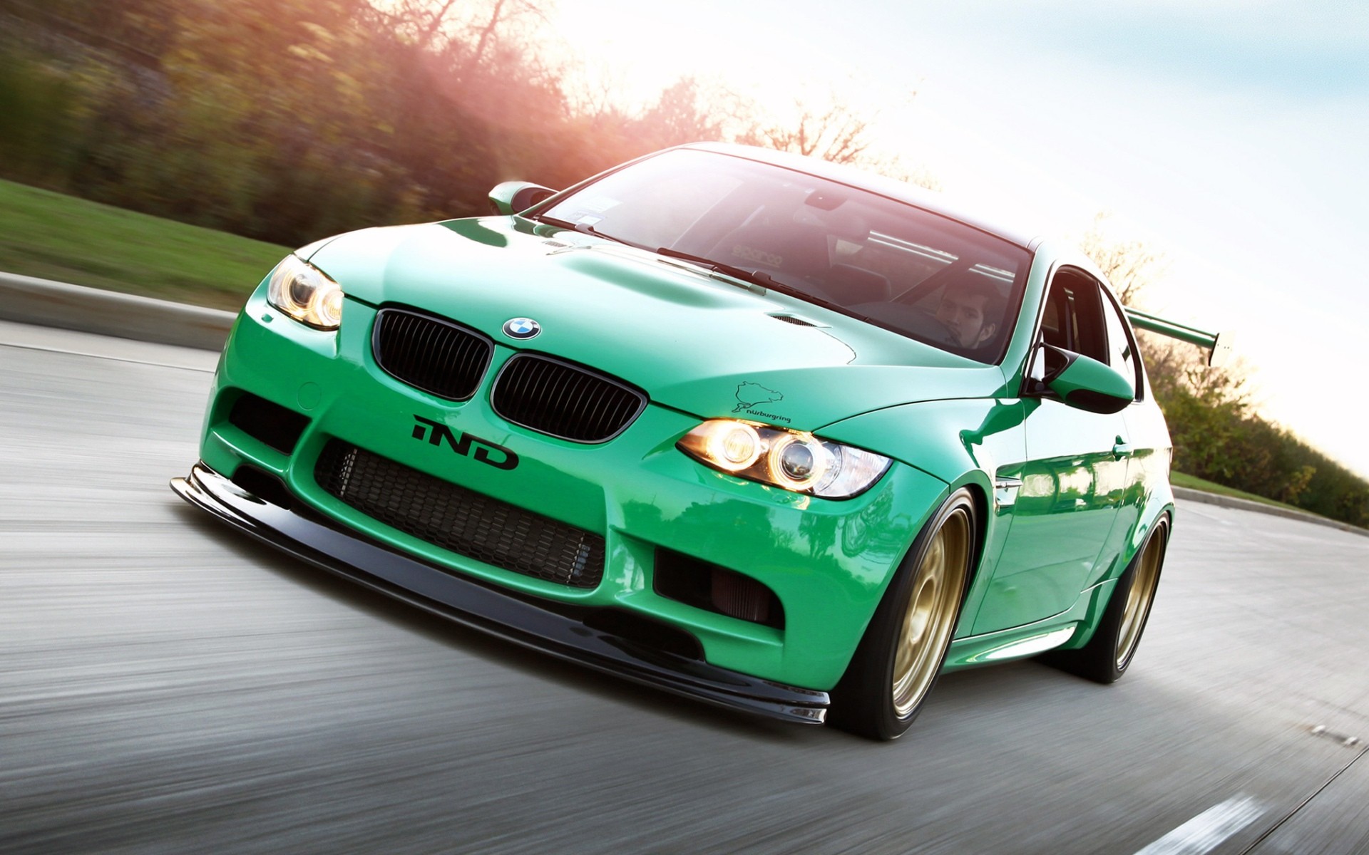 Green BMW M3 with racing decals on a road HD Wallpaper