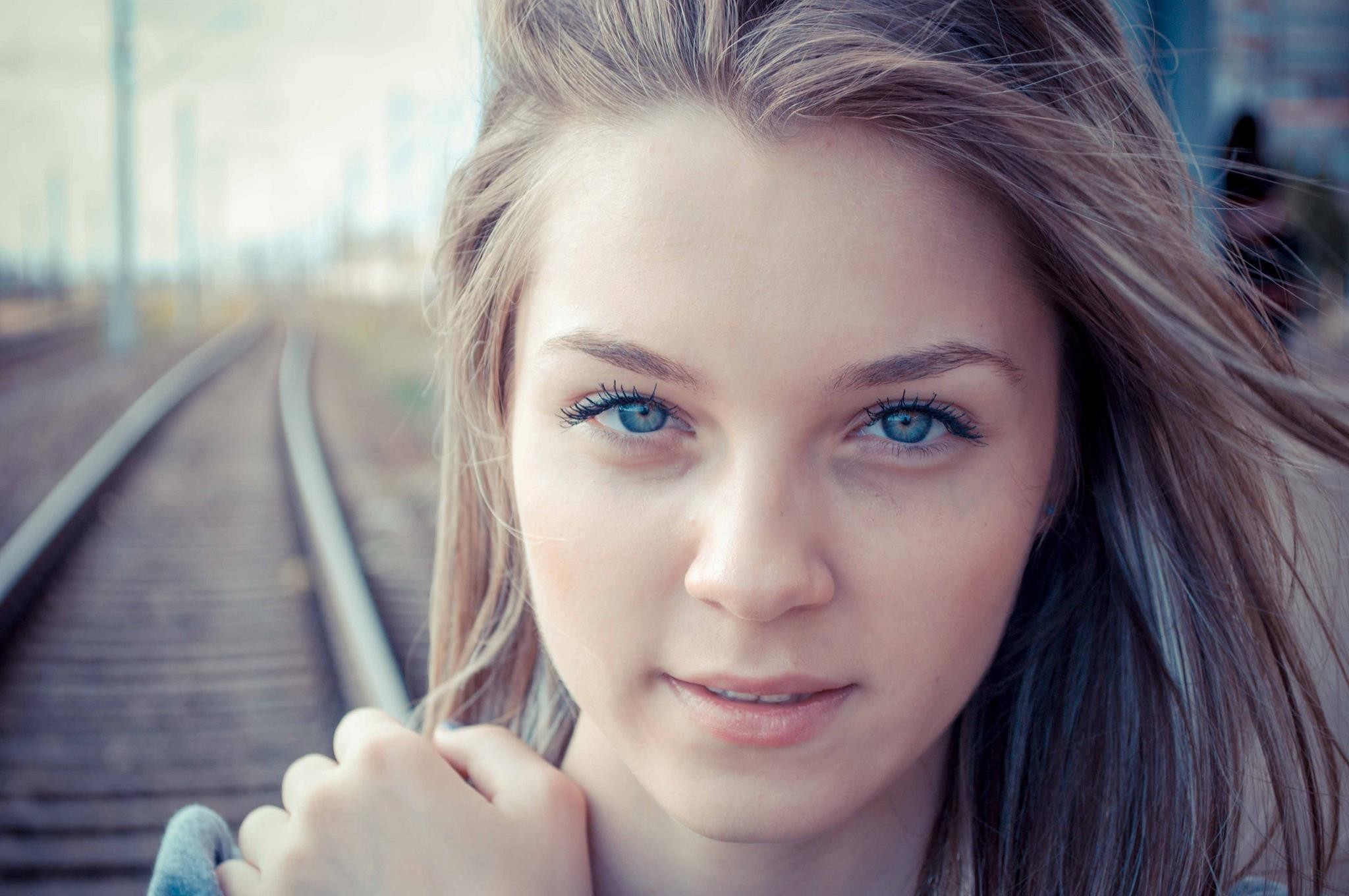 Young woman with blue eyes on train tracks HD Wallpaper