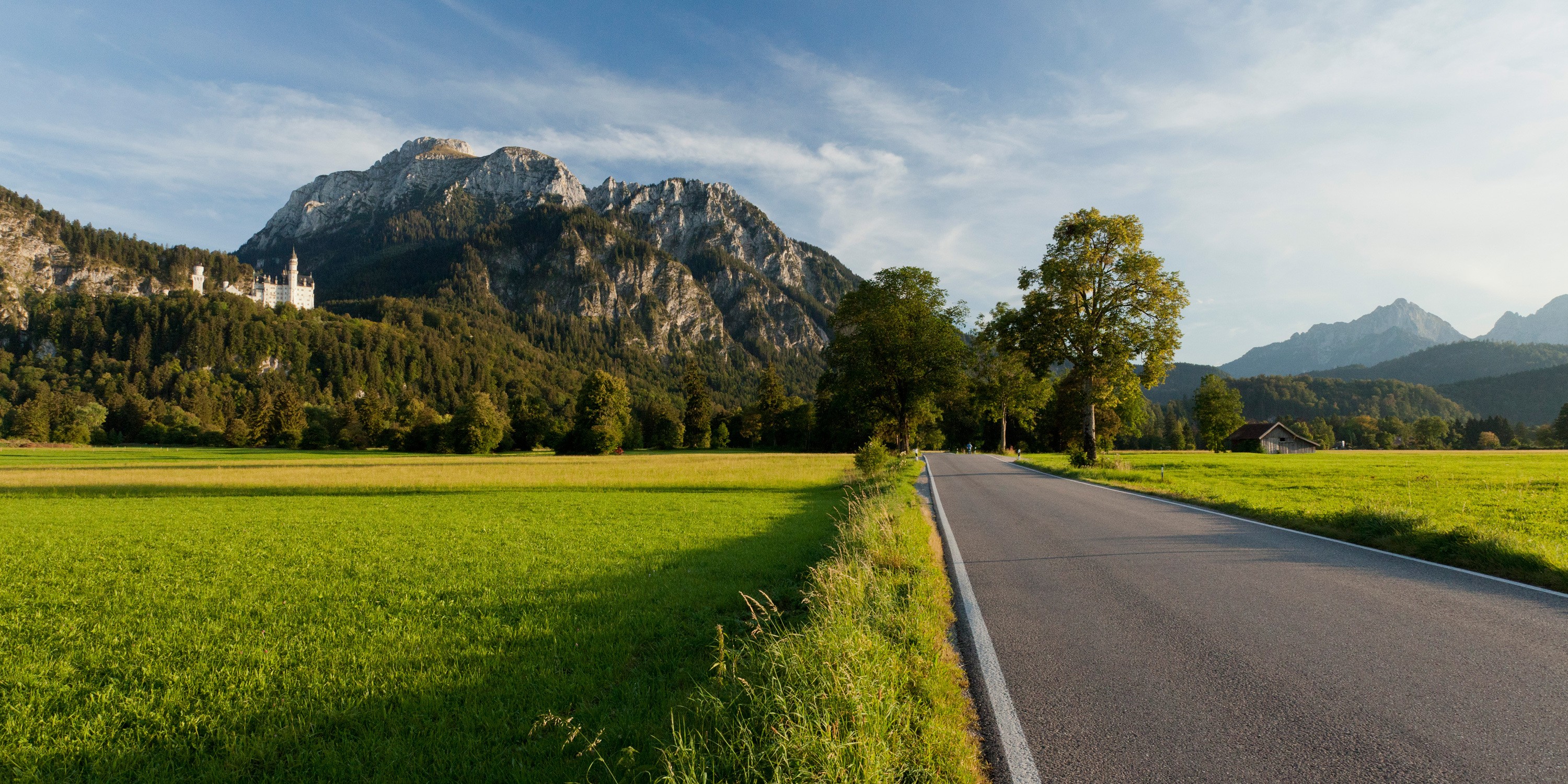 Road leading to mountains with a castle HD Wallpaper