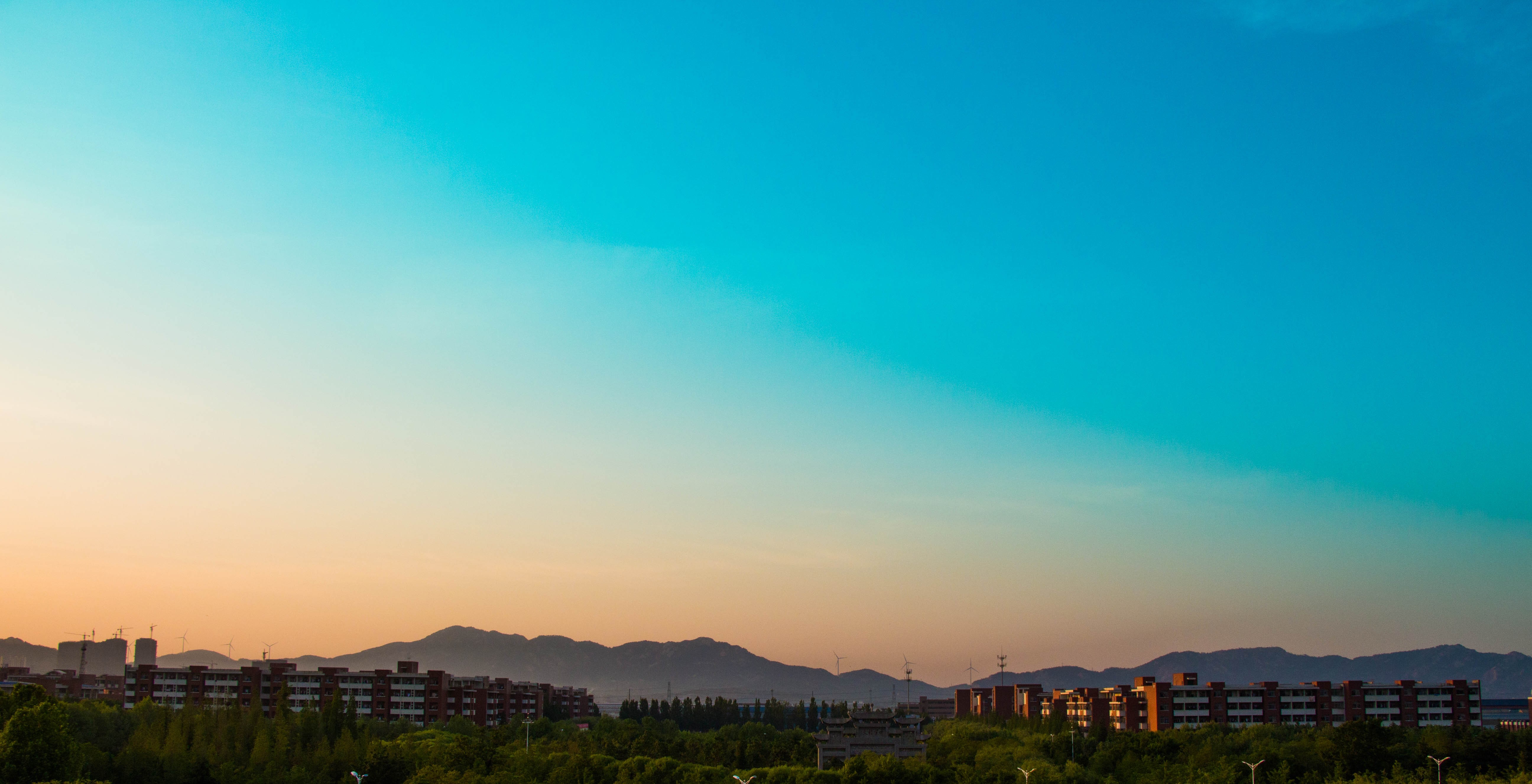 Sky over mountains and buildings at sunset HD Wallpaper