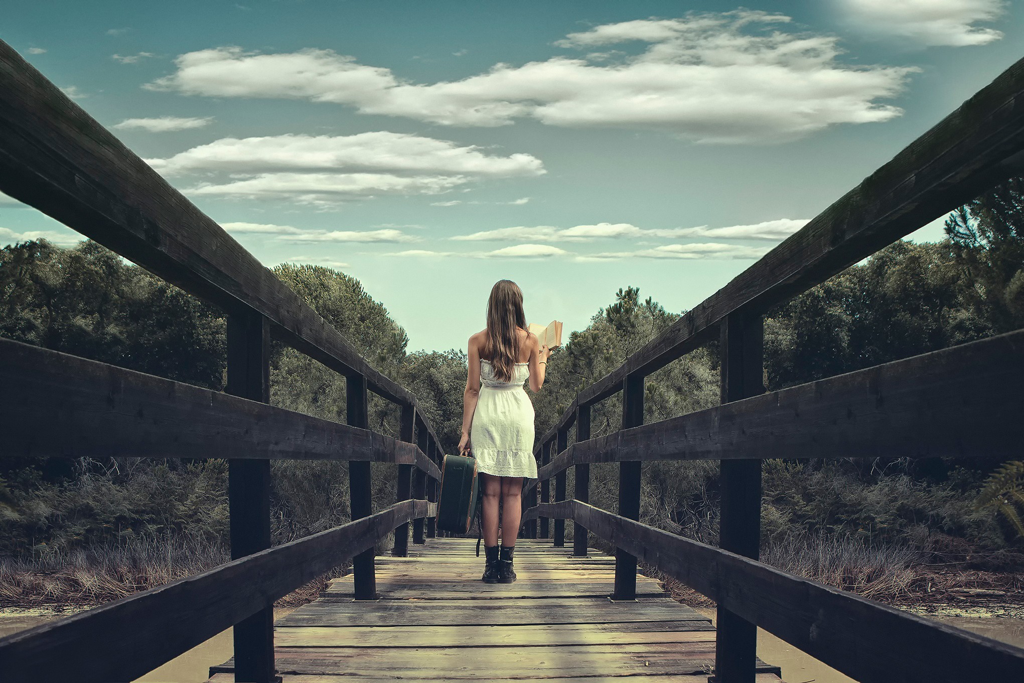 Woman with suitcase and book on a wooden bridge HD Wallpaper