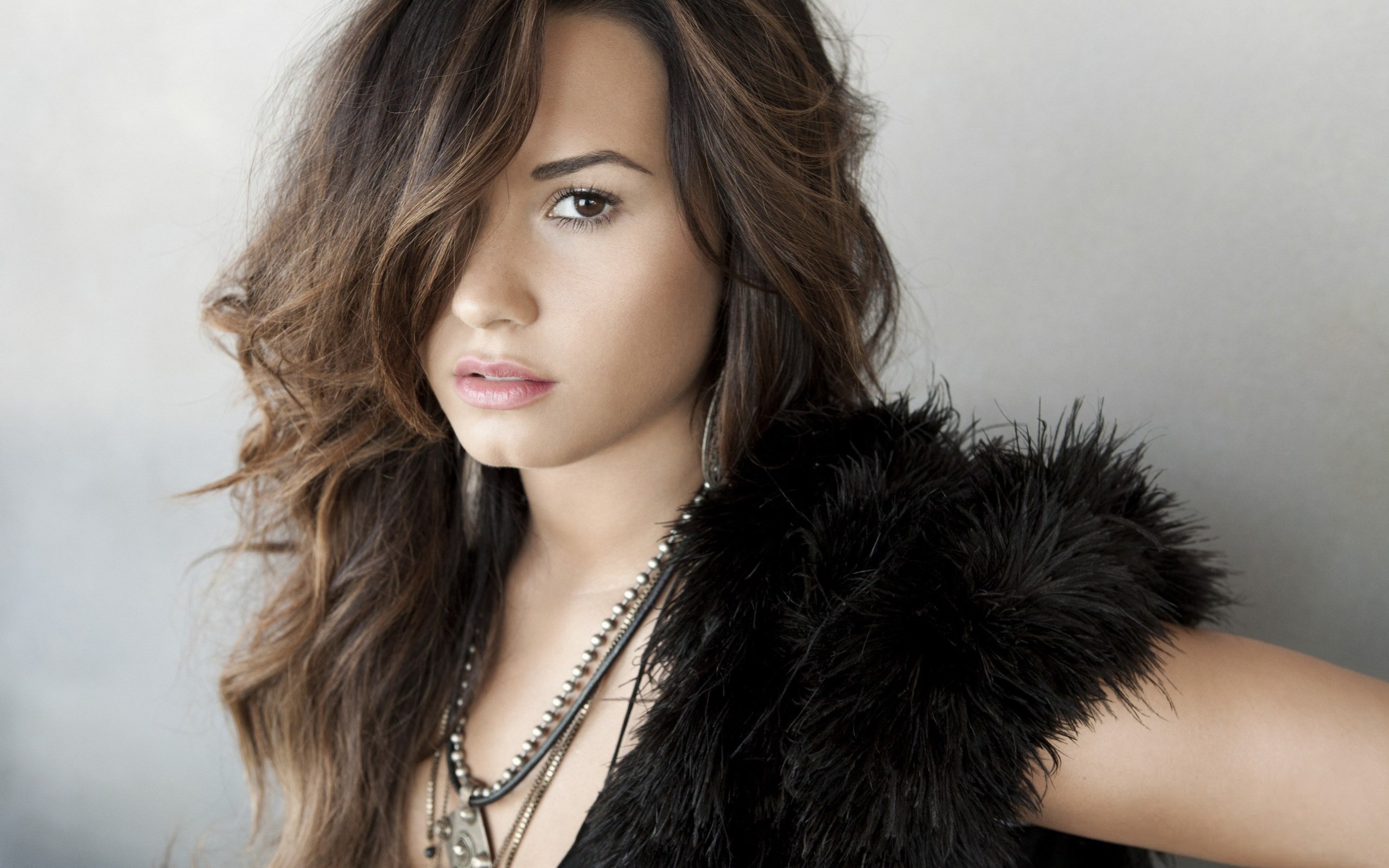 Demi Lovato with dark hair and fur vest HD Wallpaper