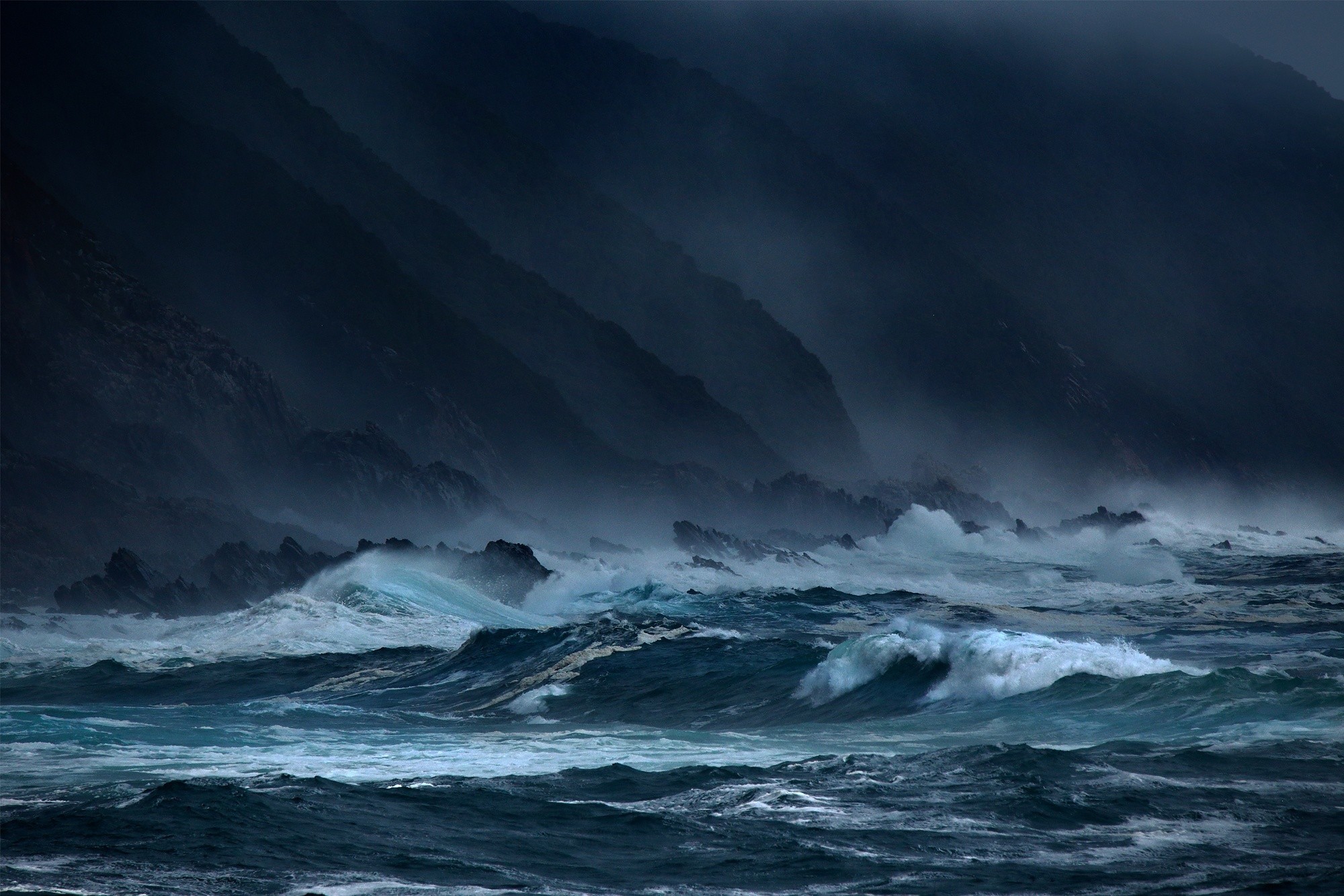 Stormy sea with waves crashing against rocky shore HD Wallpaper