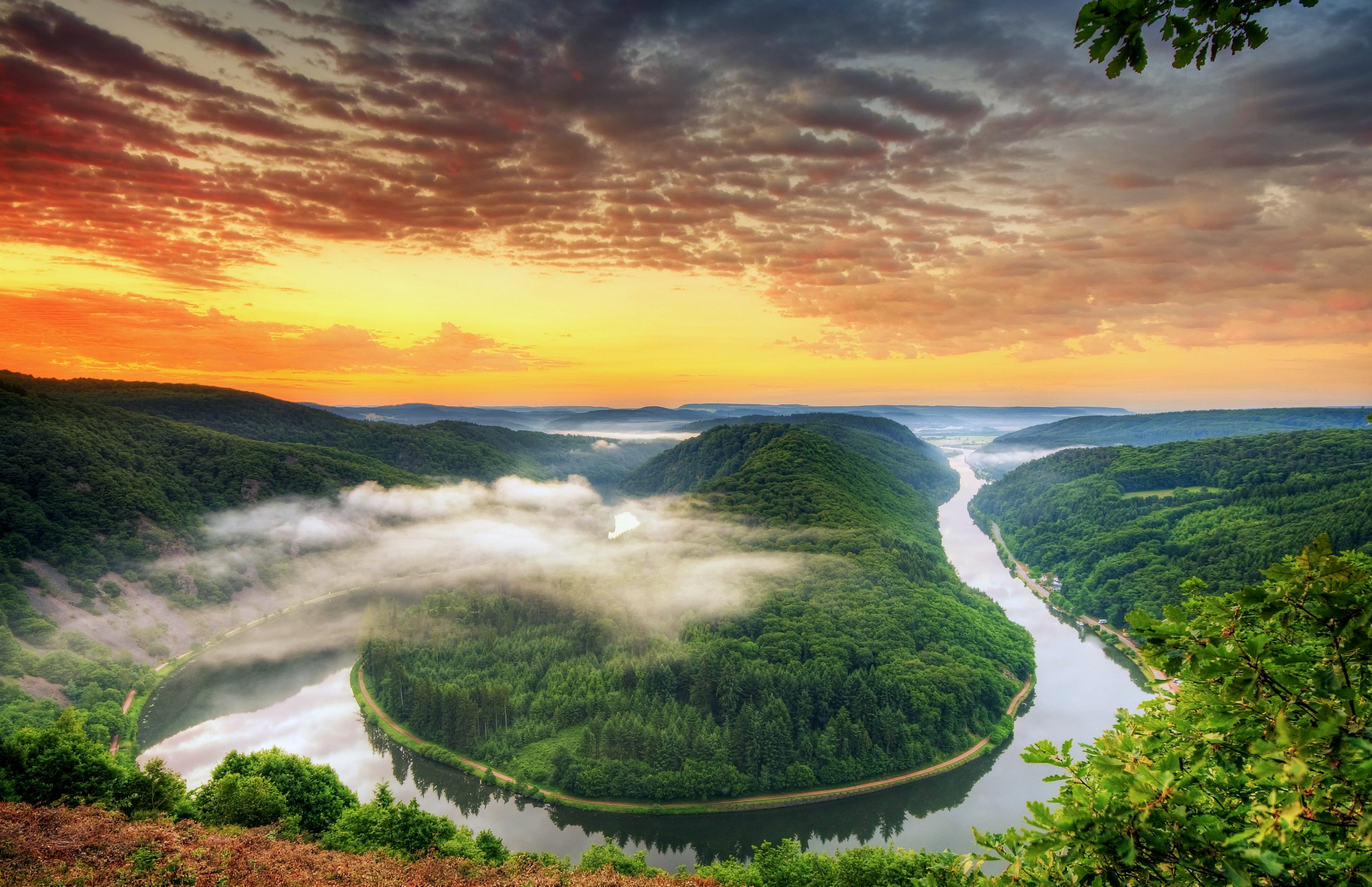 River bend through green forest at sunrise with clouds HD Wallpaper