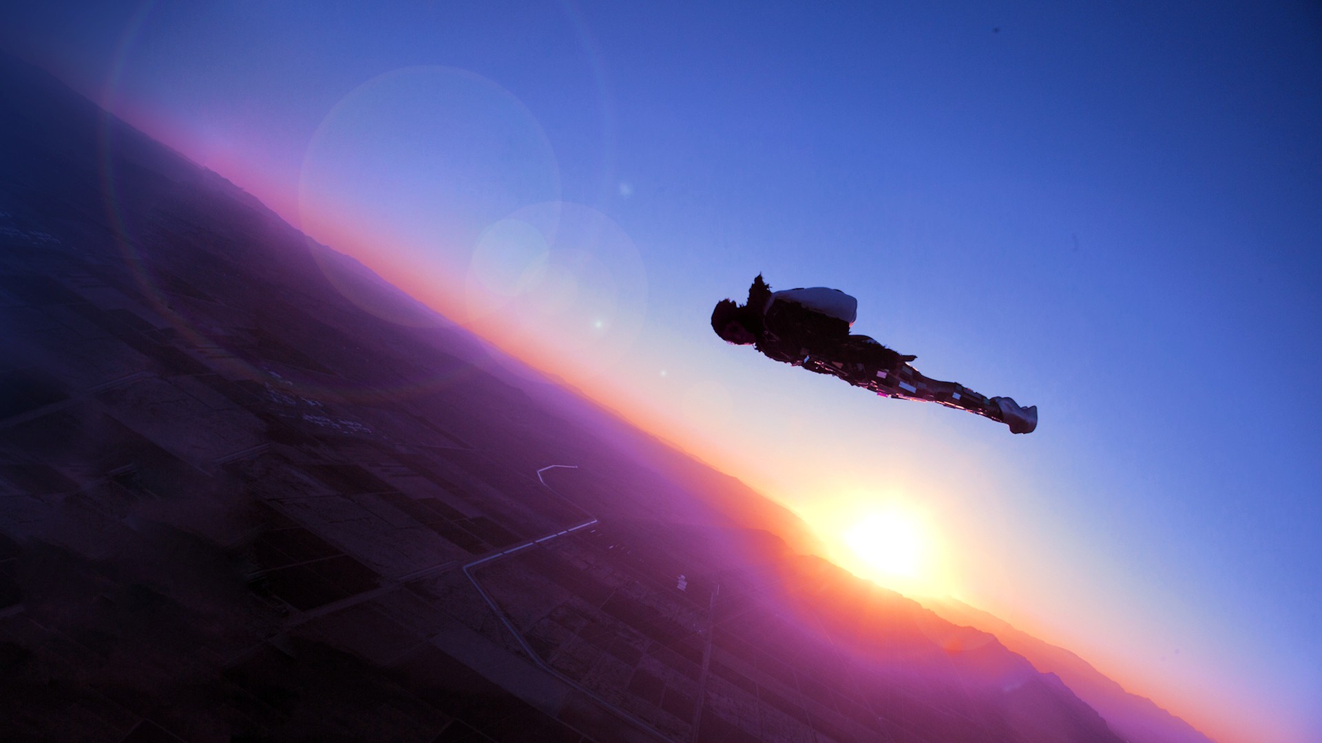 Skydiver in wingsuit during sunset HD Wallpaper