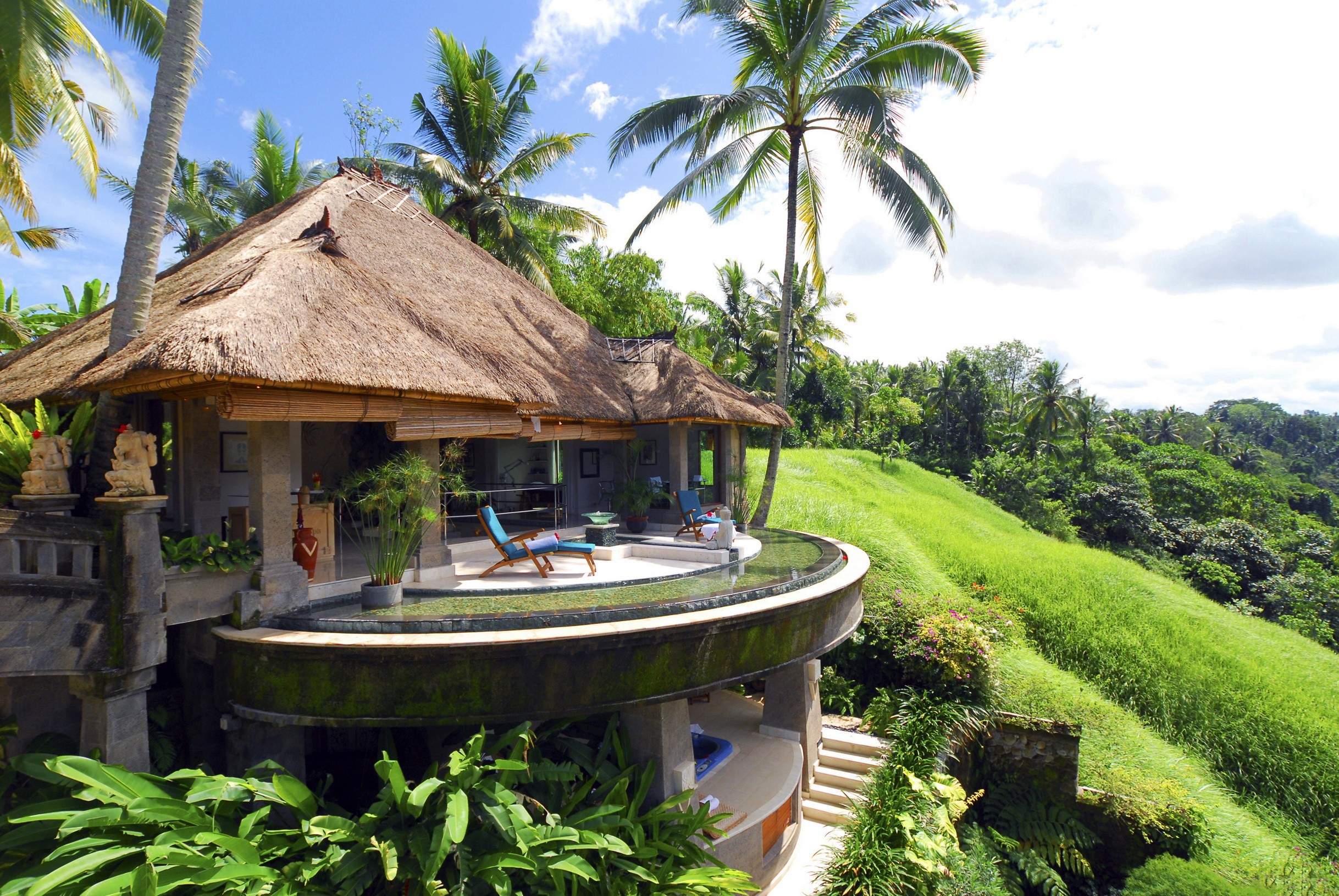 Thatched roof villa with infinity pool overlooking a tropical landscape HD Wallpaper