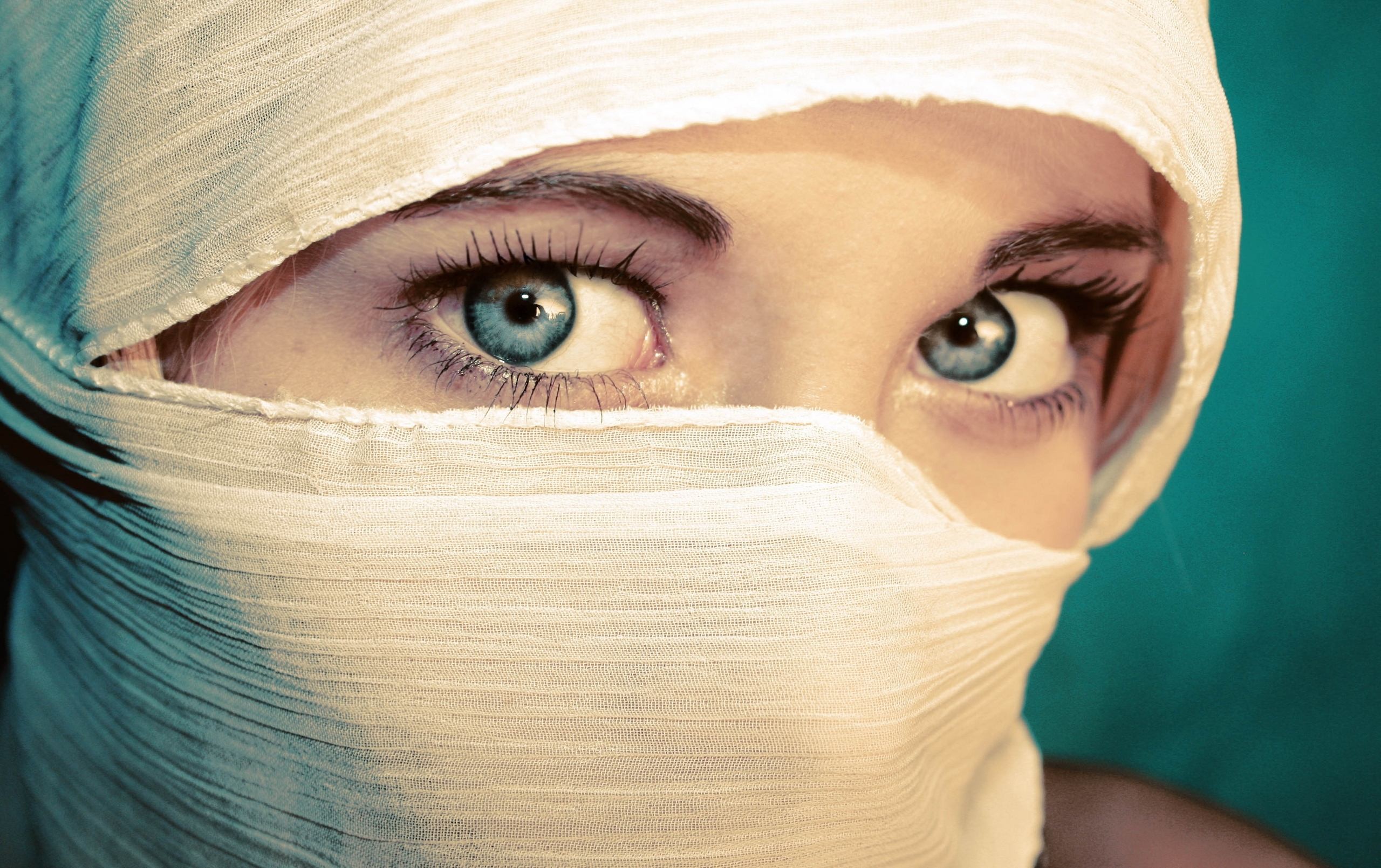 Close-up of a woman's blue eyes and face covered by white fabric HD Wallpaper